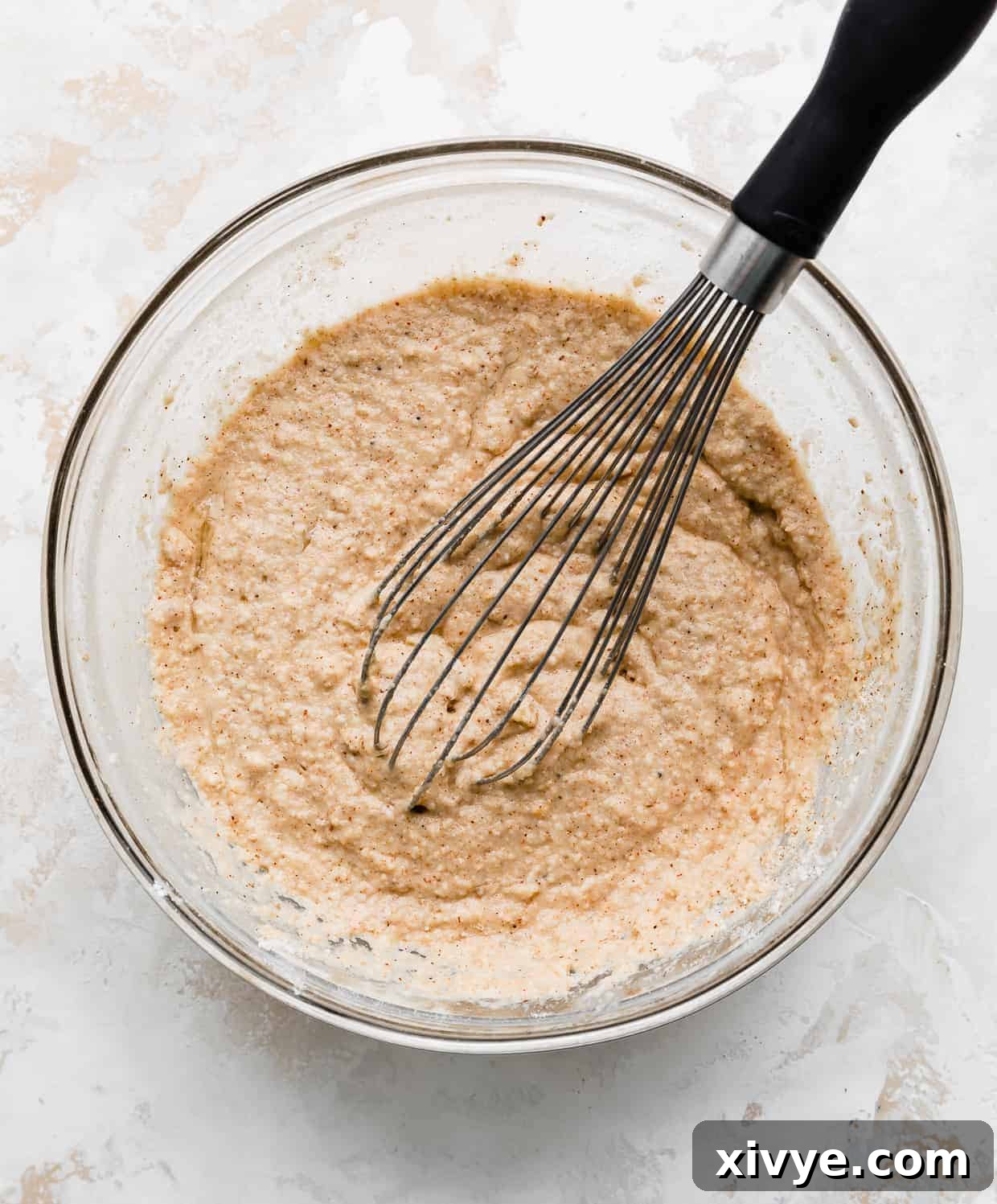 A glass bowl full of Baja fish taco batter, against a white and cream background.