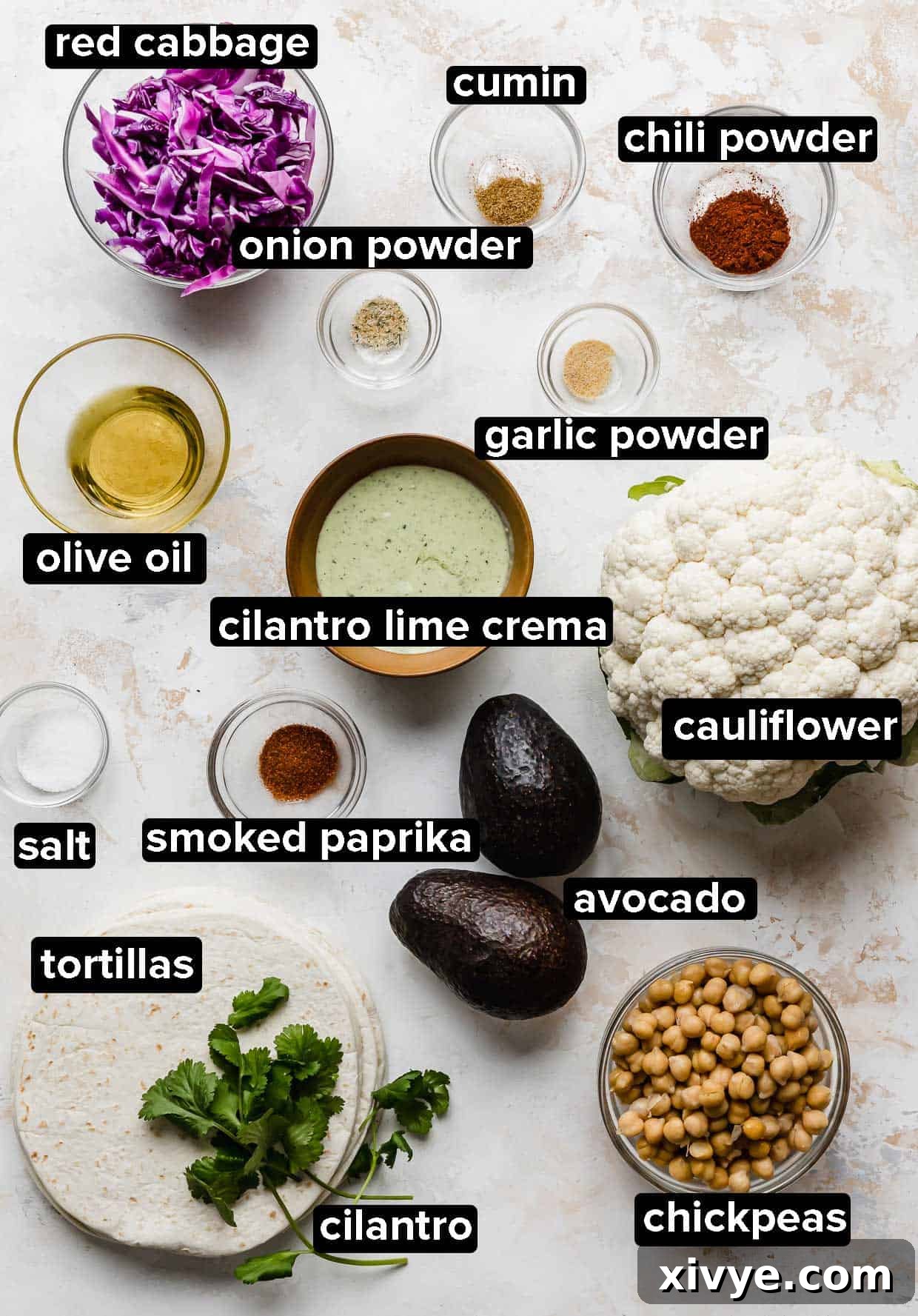 Roasted Cauliflower and chickpea Taco ingredients portioned into glass bowls on a white background.