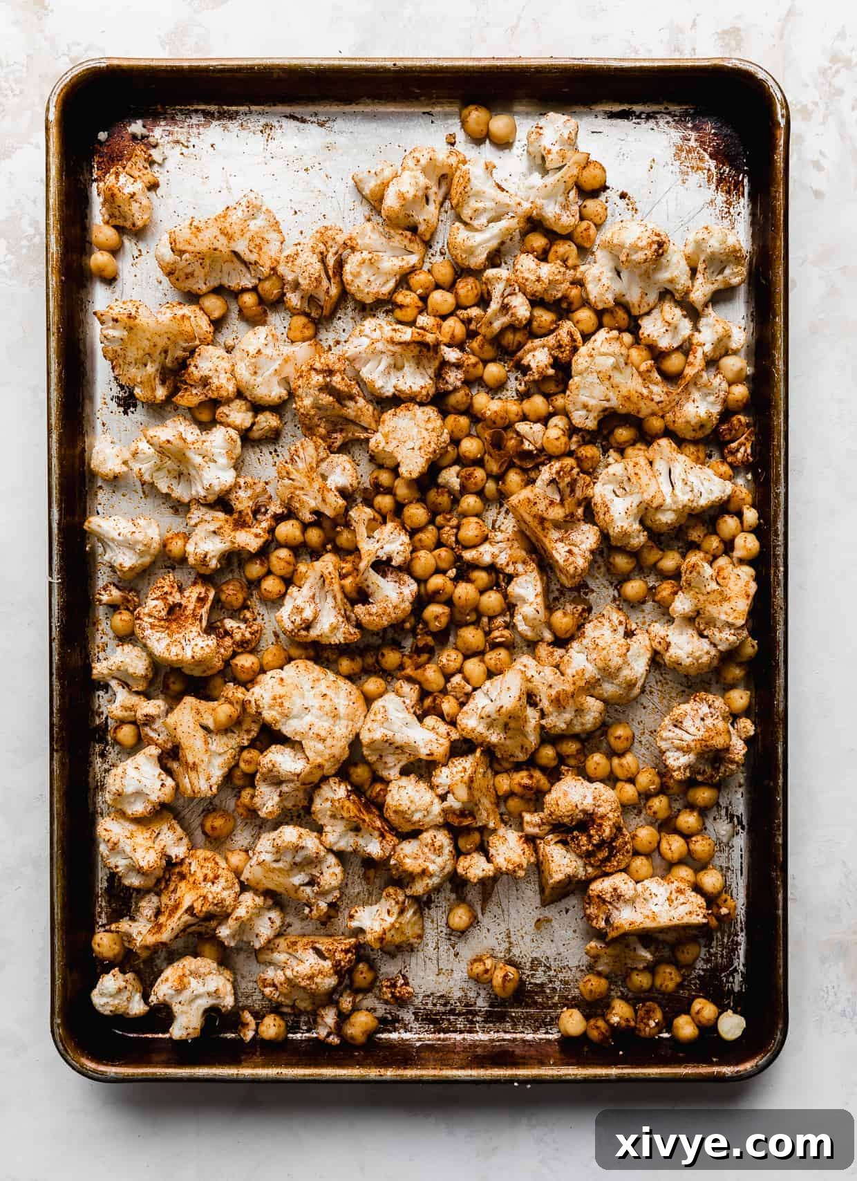 A baking sheet full of roasted cauliflower florets and chickpeas. 