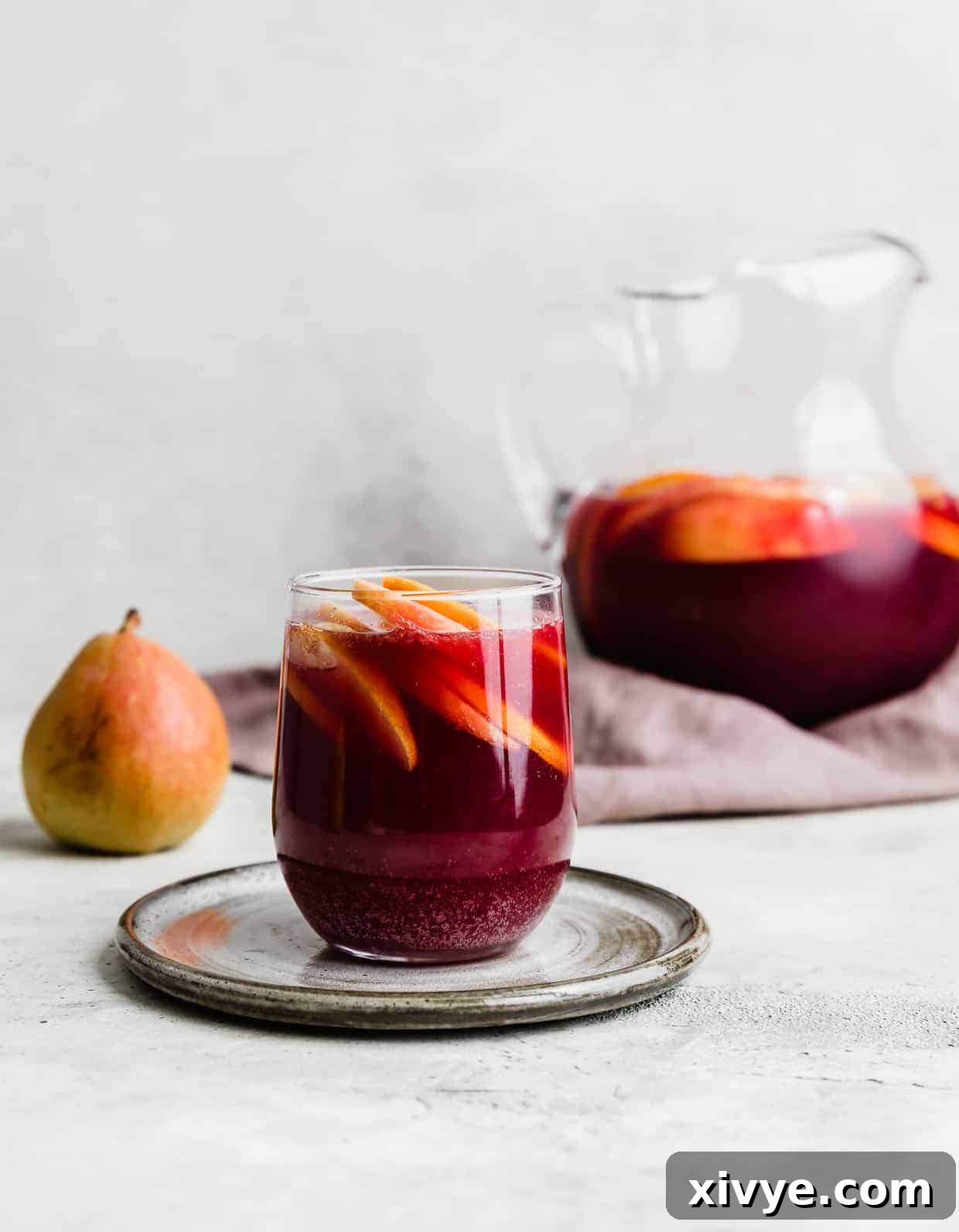 Virgin Sangria 5 A glass of dark purple colored virgin sangria sitting on a gray plate.