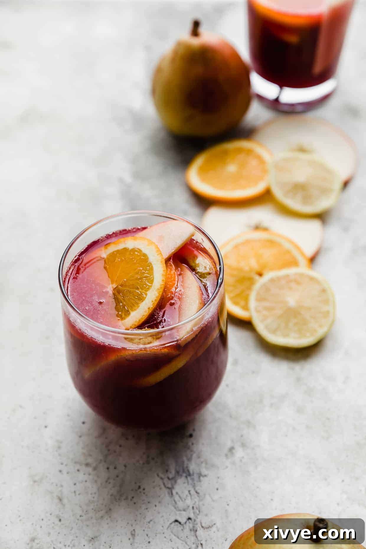 Virgin Sangria 6 Purple colored sangria with slices of oranges, lemons, and pears floating in the cup.