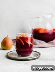 Virgin Sangria 7 A glass of dark purple colored virgin sangria sitting on a gray plate.