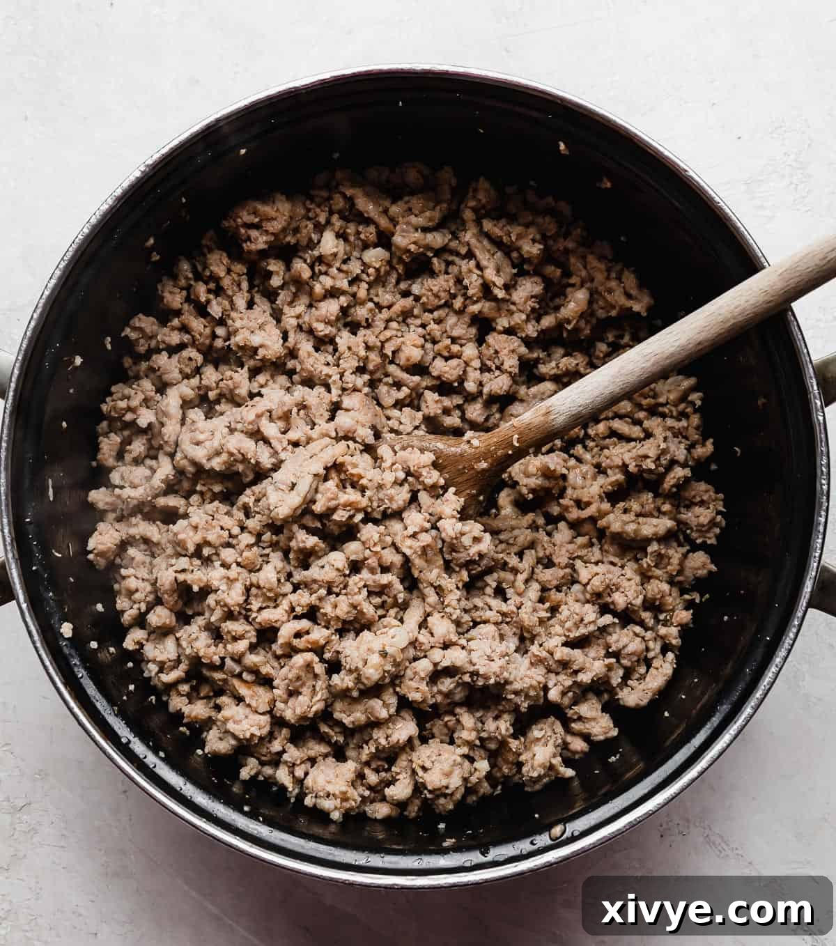 Ground Italian sausage in a black pot.