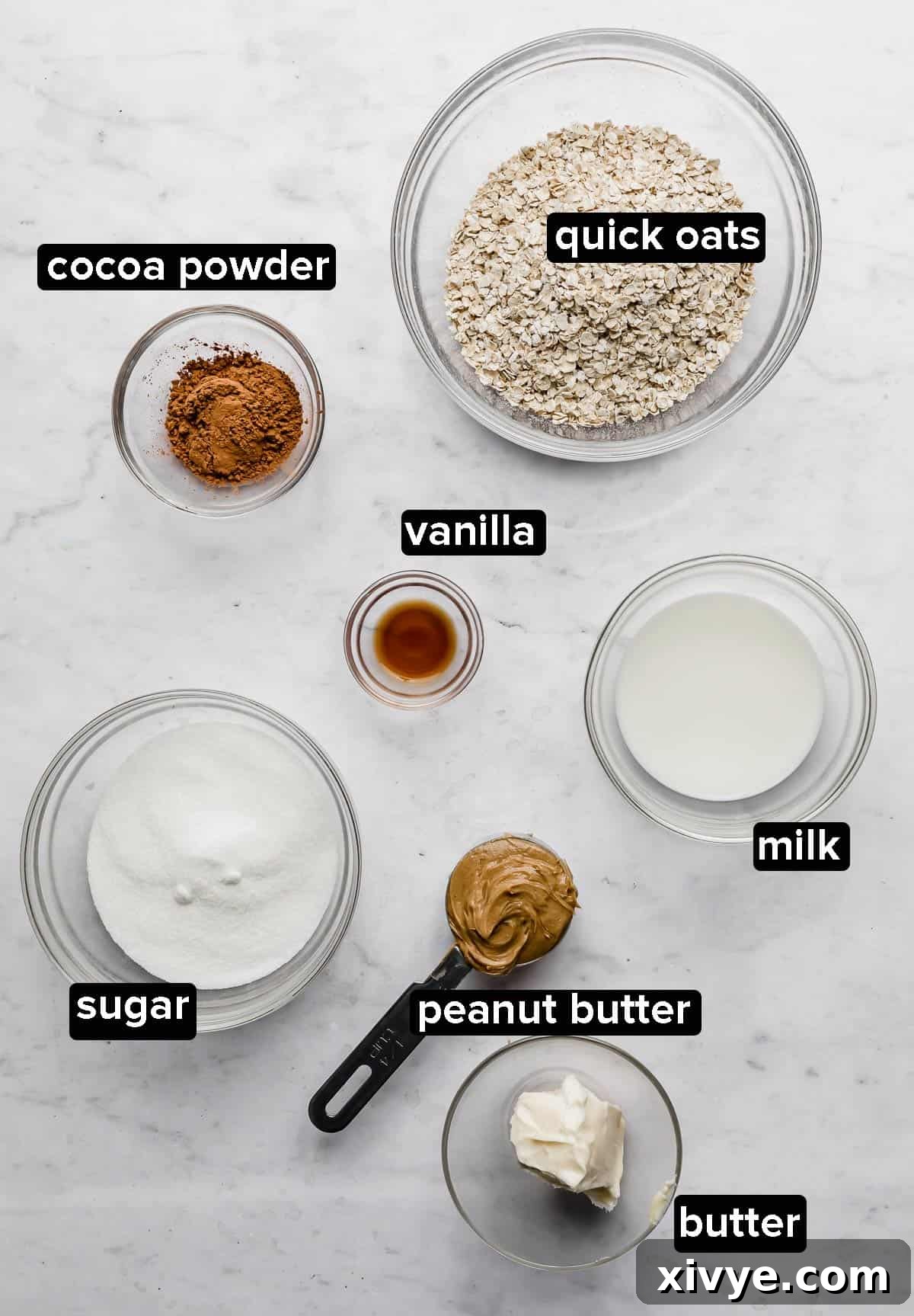 Various ingredients for chocolate peanut butter oatmeal no bake cookies, neatly arranged on a white marble background.