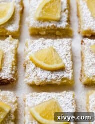 Lemon Bar squares topped with a small slice of lemon, presented beautifully.
