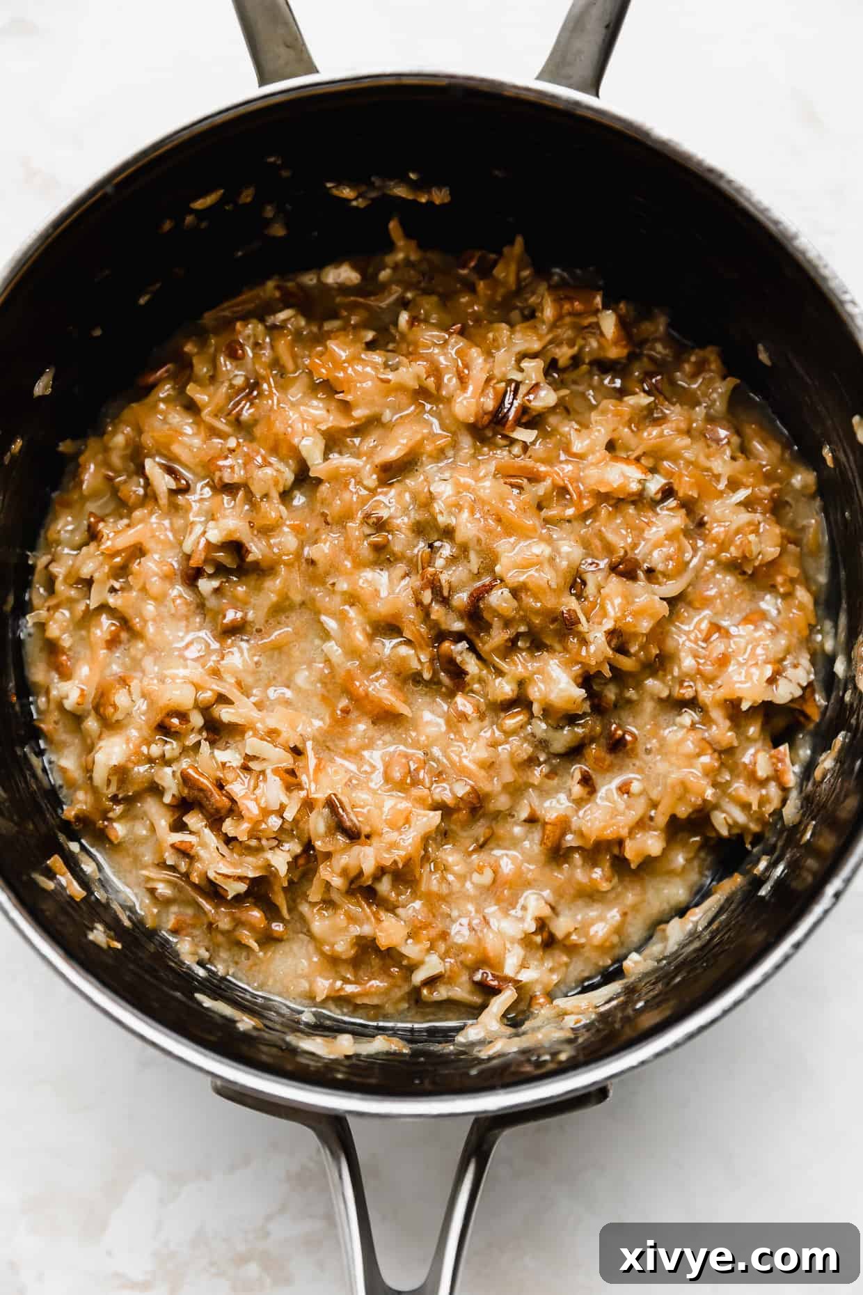Decadent Coconut Pecan Dream 9 A saucepan with brown and tan colored coconut pecan frosting for a German Chocolate Cake.