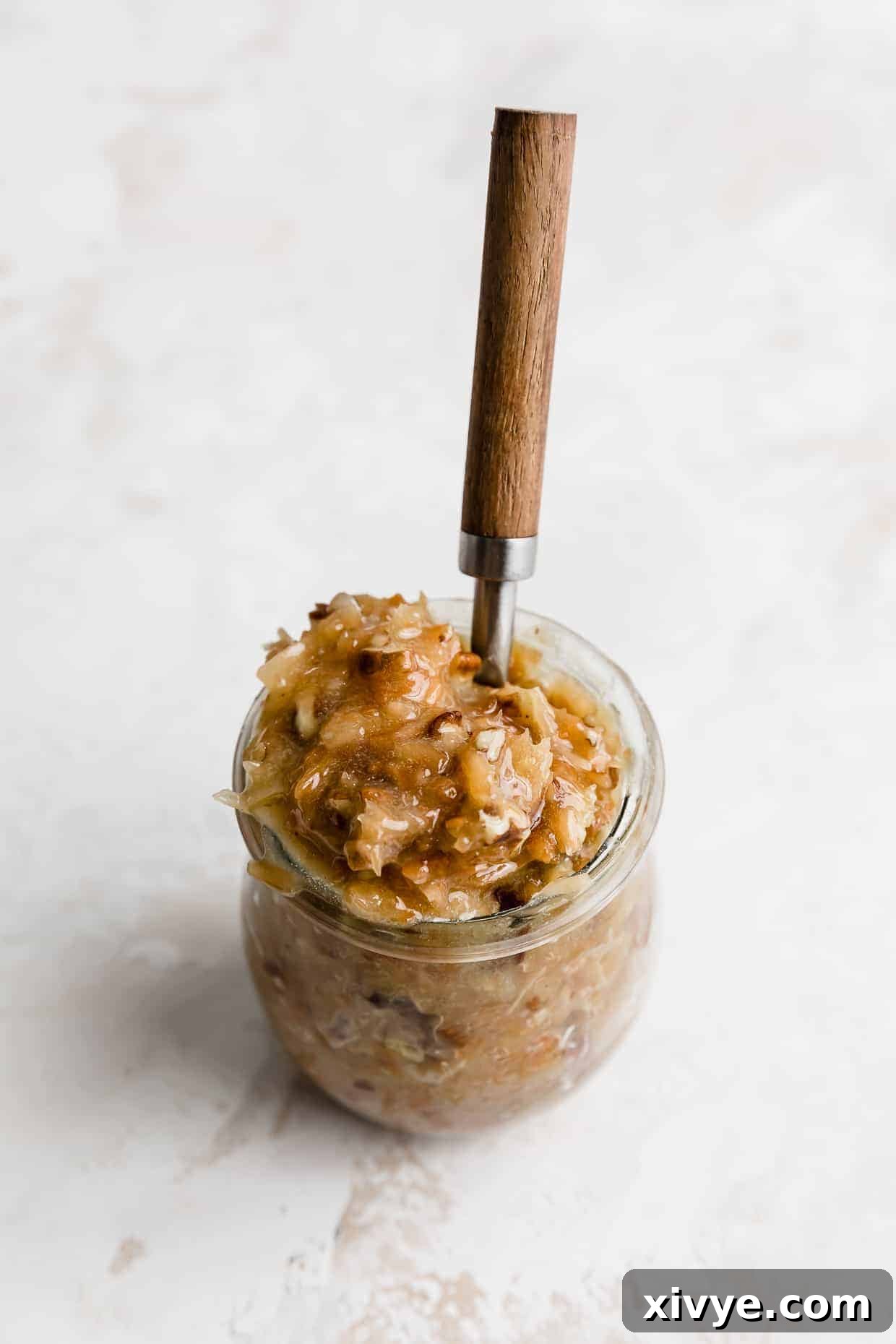 Decadent Coconut Pecan Dream 10 A small glass jar full of German Chocolate Cake frosting with a spoon sticking in the jar too.