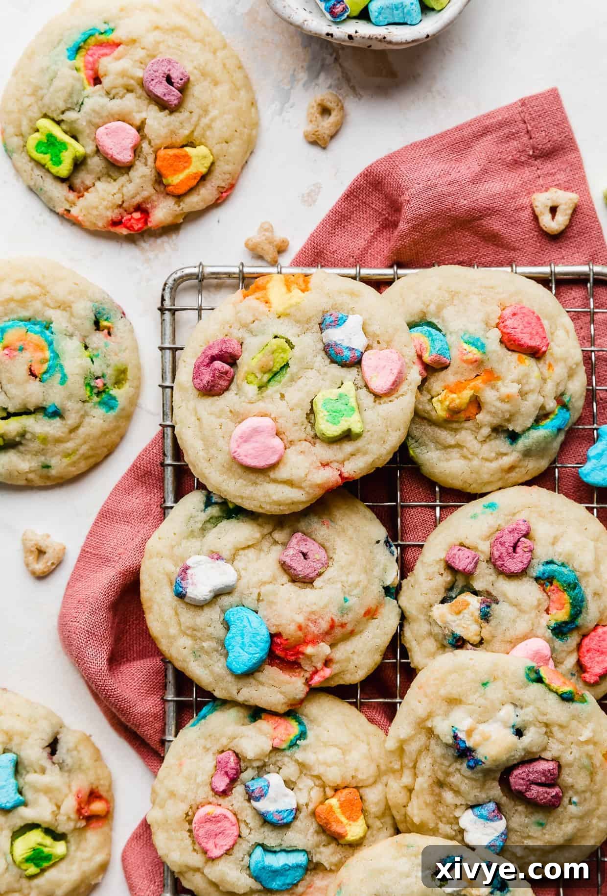 Lucky Charms Cookies on a dark pink napkin against a white background. 