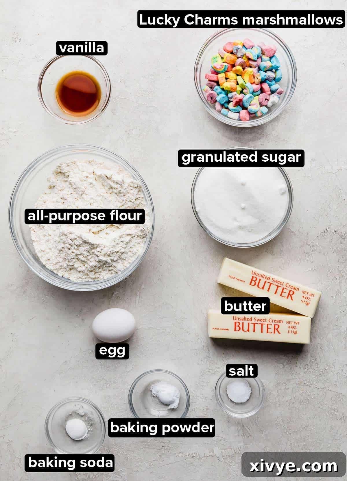 Lucky Charms Cookies ingredients in glass bowls on a light grey background.