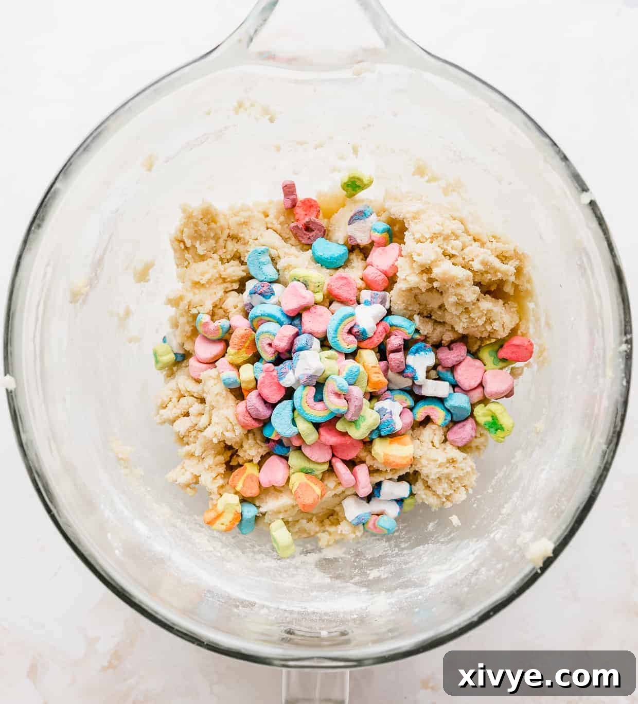 Lucky Charms cereal marshmallows in a glass bowl against a white background.