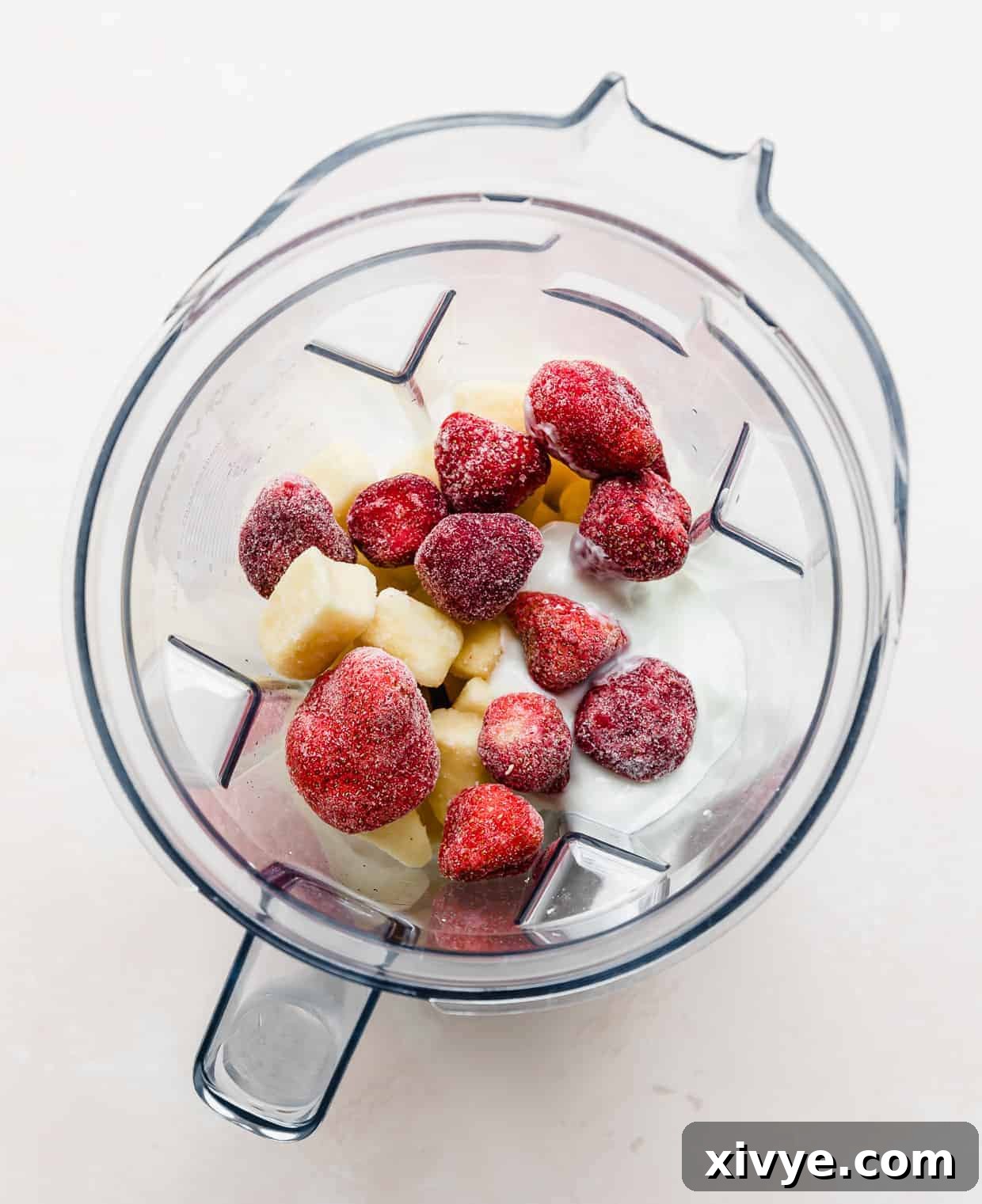 Tropical Strawberry Pineapple Smoothie 5 A blender full of frozen pineapple, bananas, strawberries, milk, and yogurt.