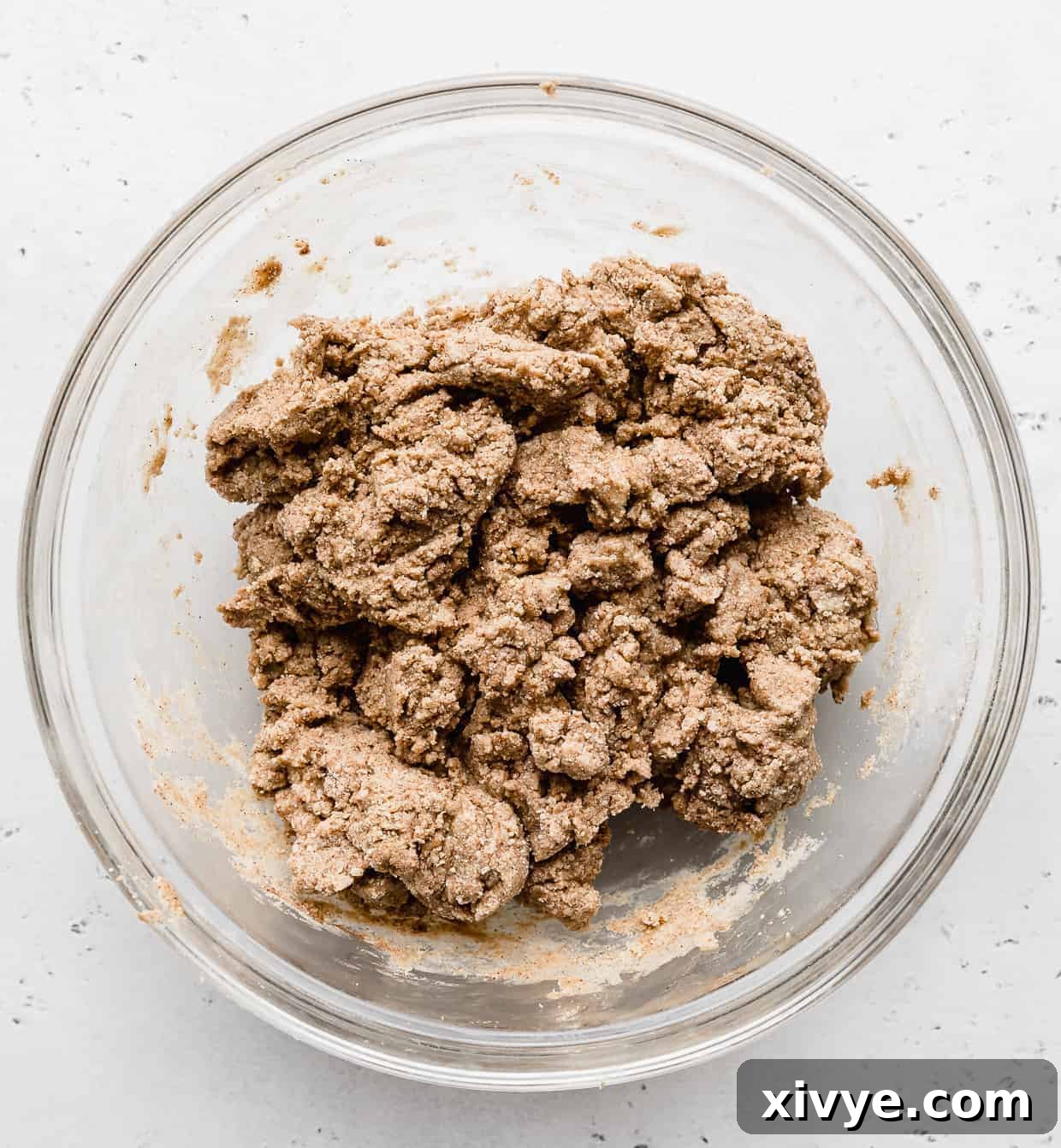 Snickerdoodle Energy Bites batter in a glass bowl against a white background.