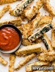 Crispy zucchini fries on a white plate.