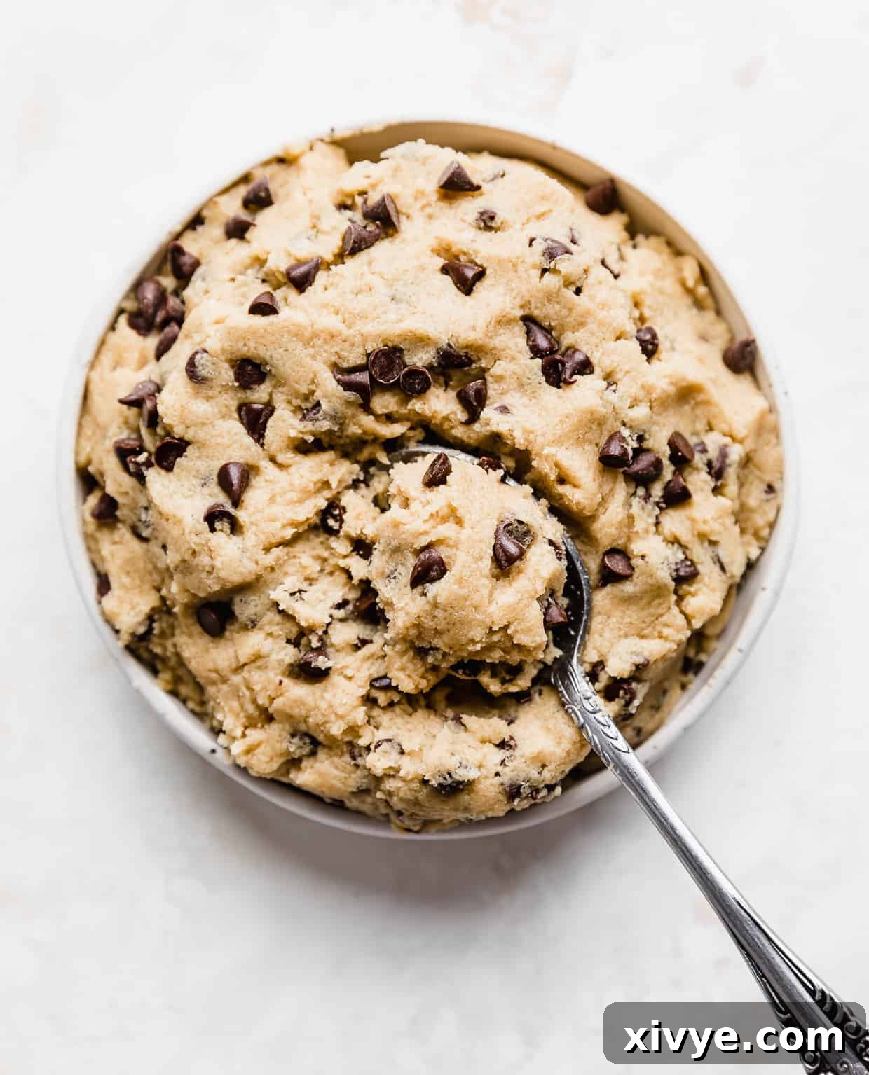 Ben and Jerrys Irresistible Cookie Dough Bites 3 A plate full of chocolate chip cookie dough with a spoon scooping up a portion of the dough.