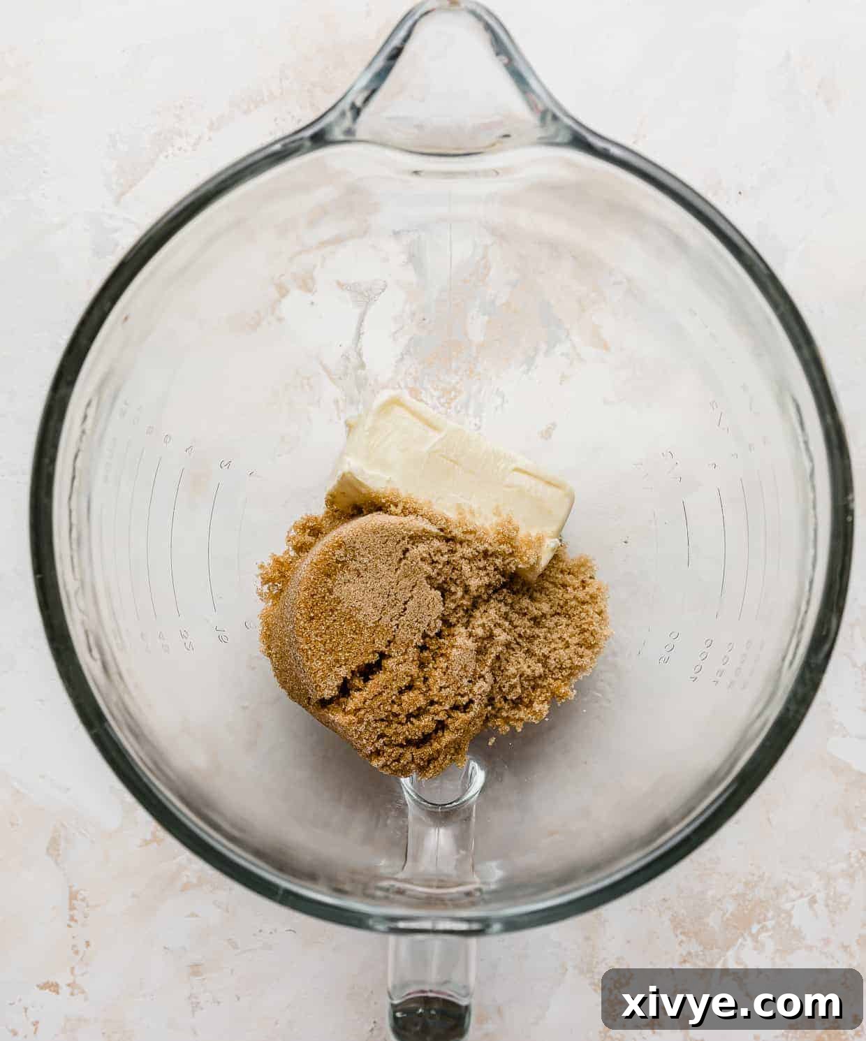 Ben and Jerrys Irresistible Cookie Dough Bites 5 A glass mixing bowl with a stick of butter and light brown sugar in it.