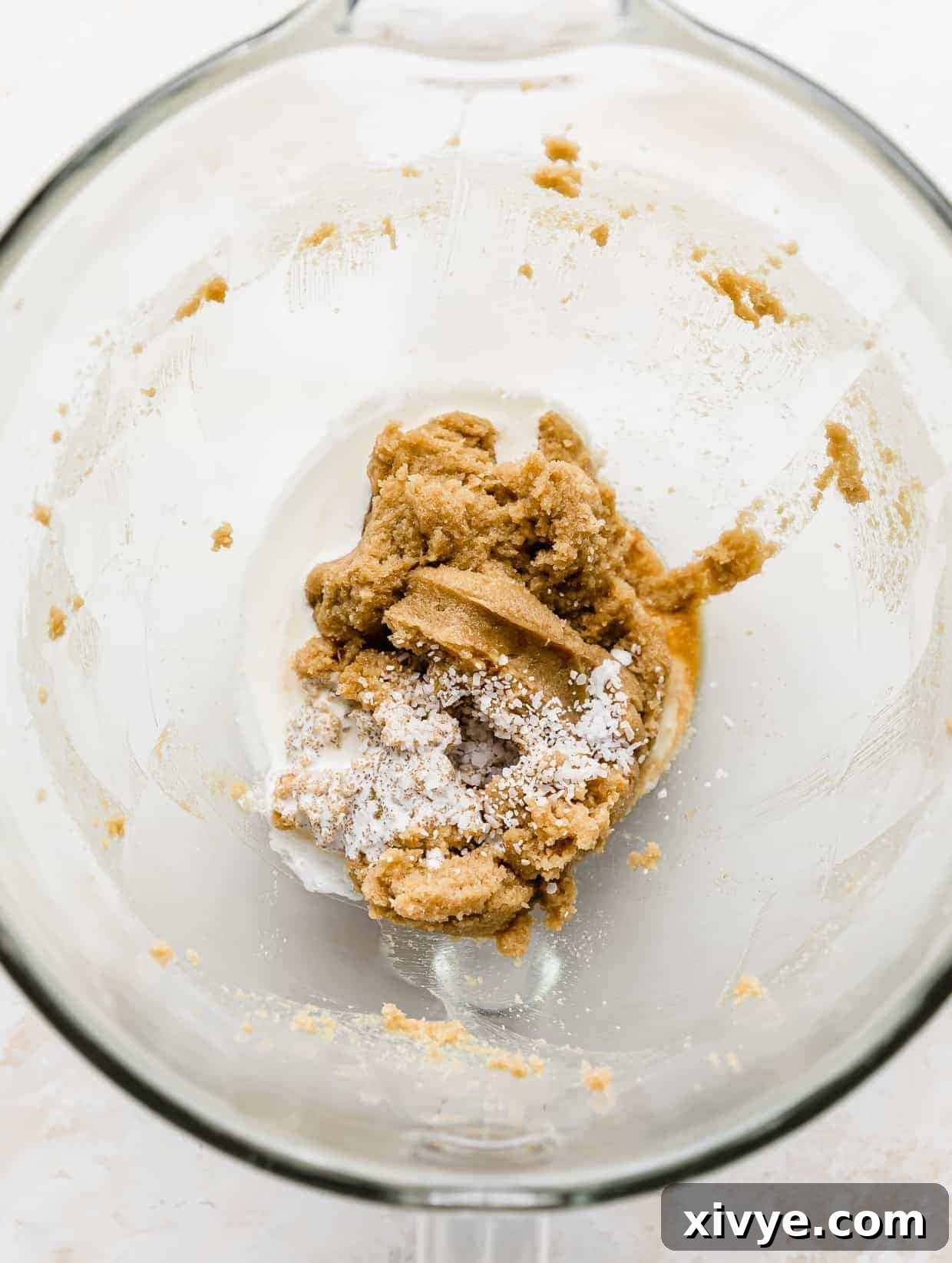 Ben and Jerrys Irresistible Cookie Dough Bites 6 Creamed butter and sugar in a glass bowl with salt, vanilla, and heavy cream added overtop.