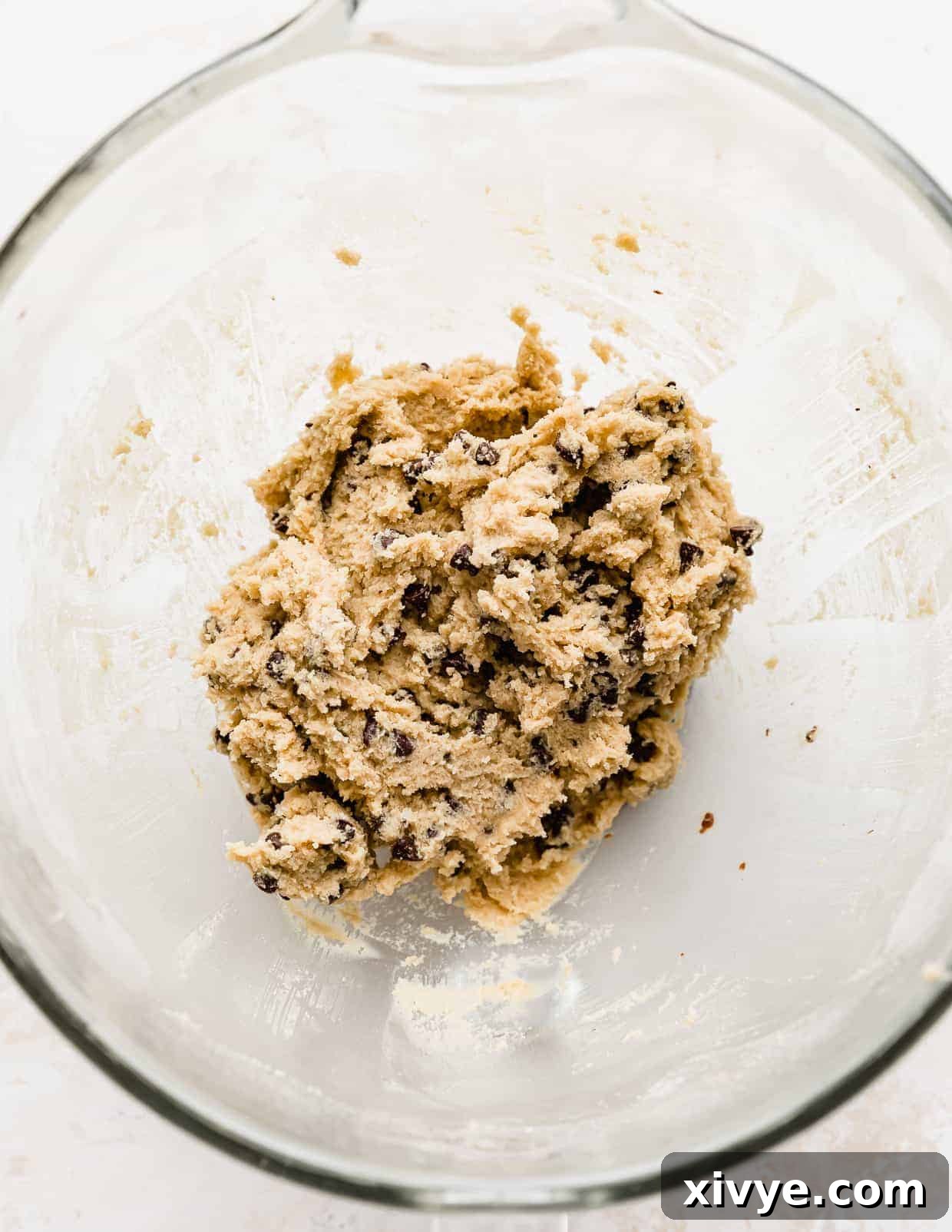 Ben and Jerrys Irresistible Cookie Dough Bites 10 Ben and Jerry's edible cookie dough studded with mini chocolate chips, in a glass mixing bowl against a white background.