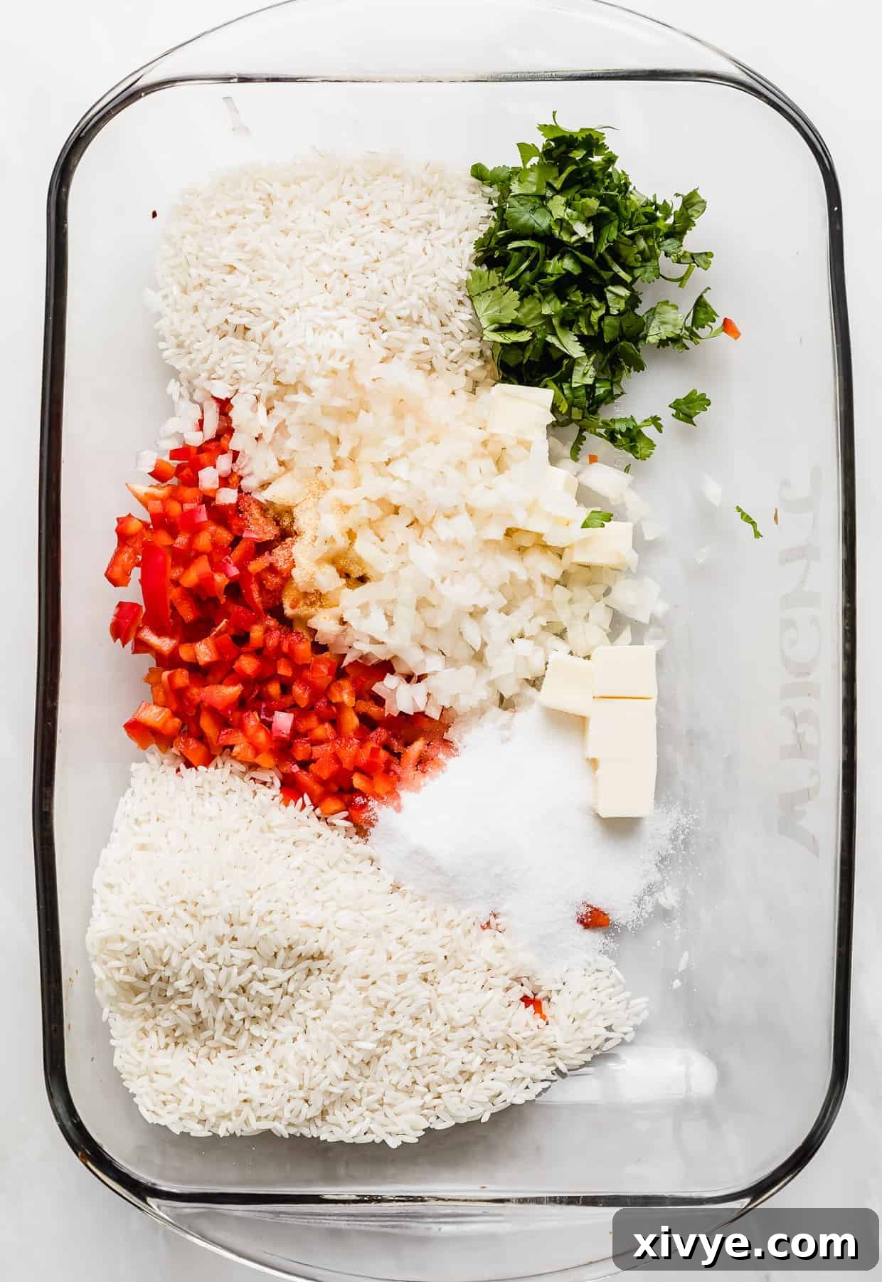 Sweet Bell Pepper Pilaf 3 A glass baking dish with chopped red pepper, cilantro, white rice, sugar, salt and spices in it.