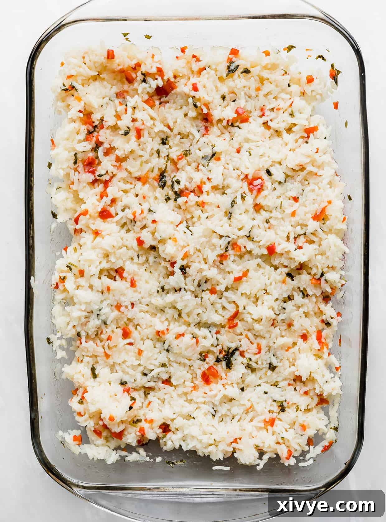 Sweet Bell Pepper Pilaf 5 A glass baking dish full of Sweet Pepper Rice with red and green studded peppers and cilantro throughout.