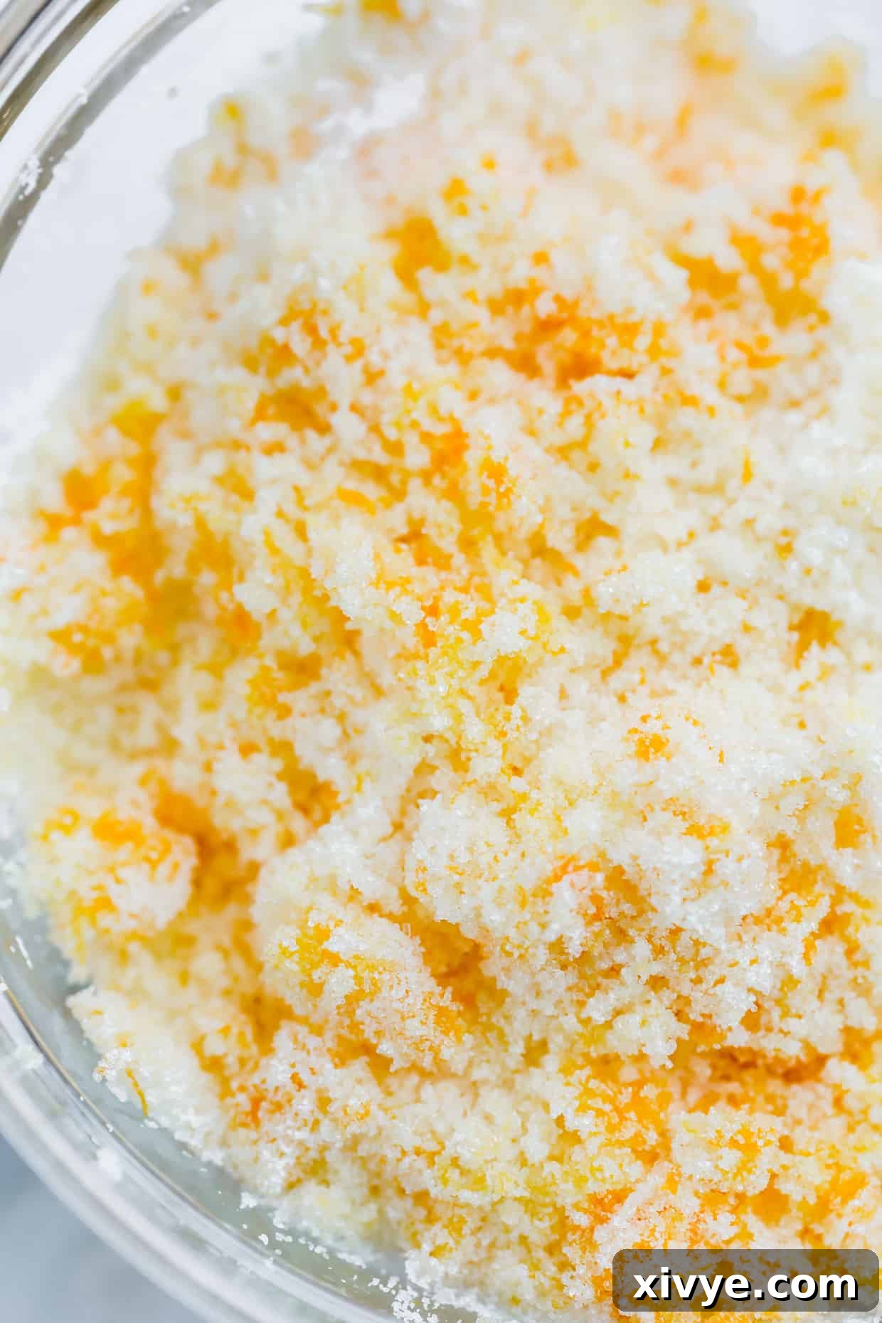 Orange sugar mixture in preparation for making easy homemade orange sweet rolls.