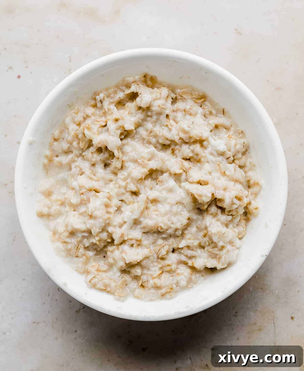 A white bowl with cooked rolled oats in it. 