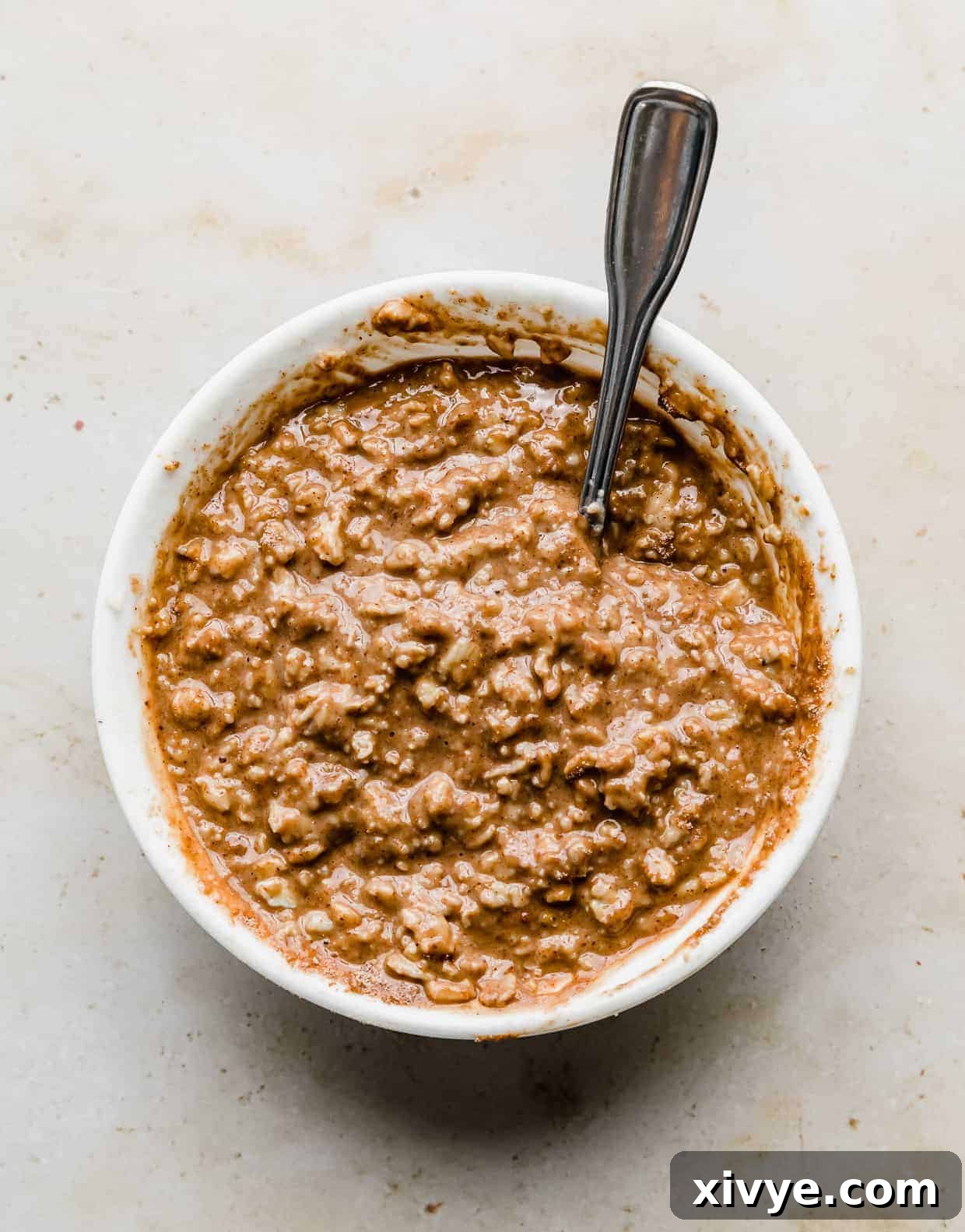 Brown colored oatmeal in a white bowl.