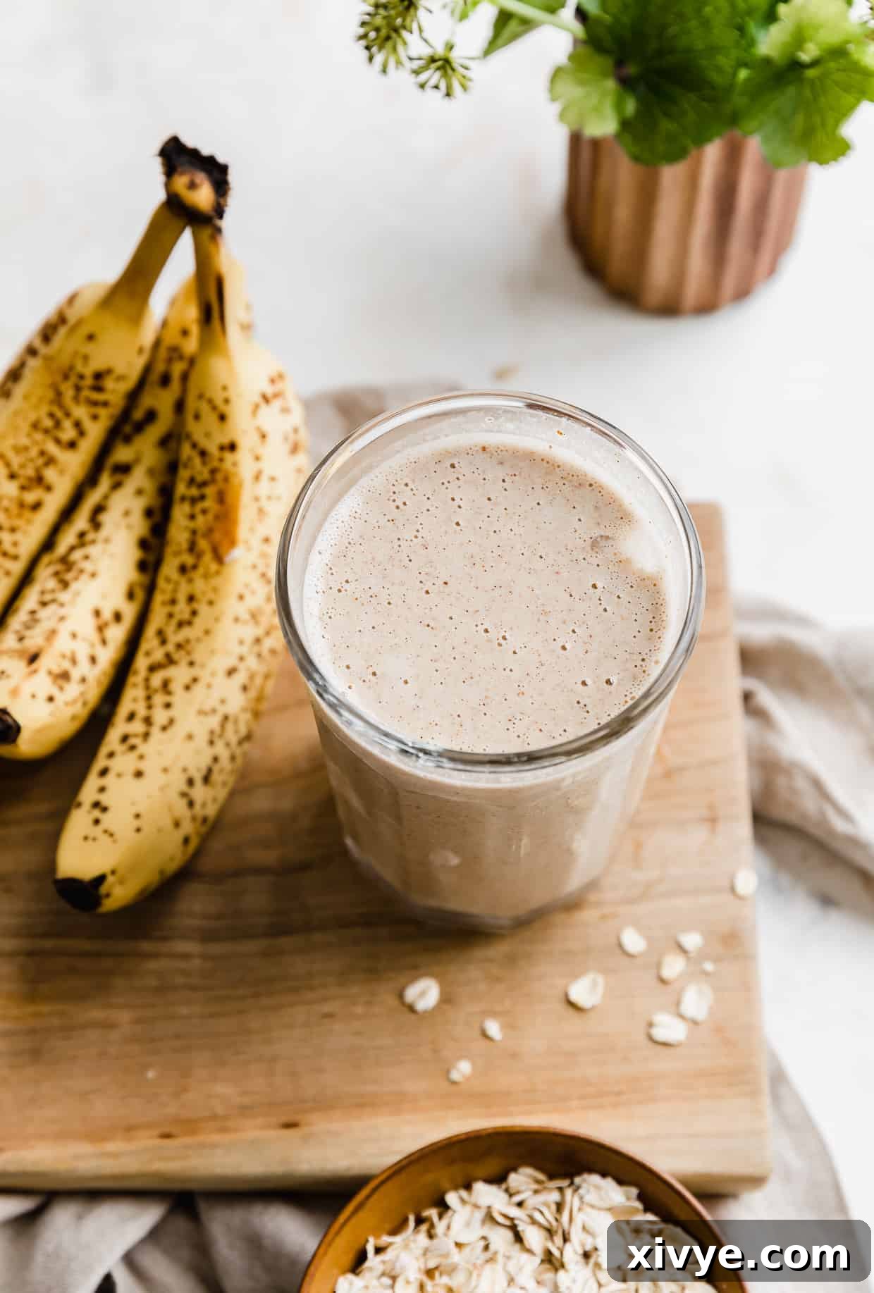 Mama's Milk Smoothie 7 A lactation smoothie on a wooden board, with bananas next to the cup.