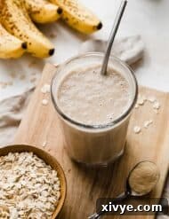 Mama's Milk Smoothie 8 A Lactation Smoothie on a small wooden cutting board with ripe bananas in the background.