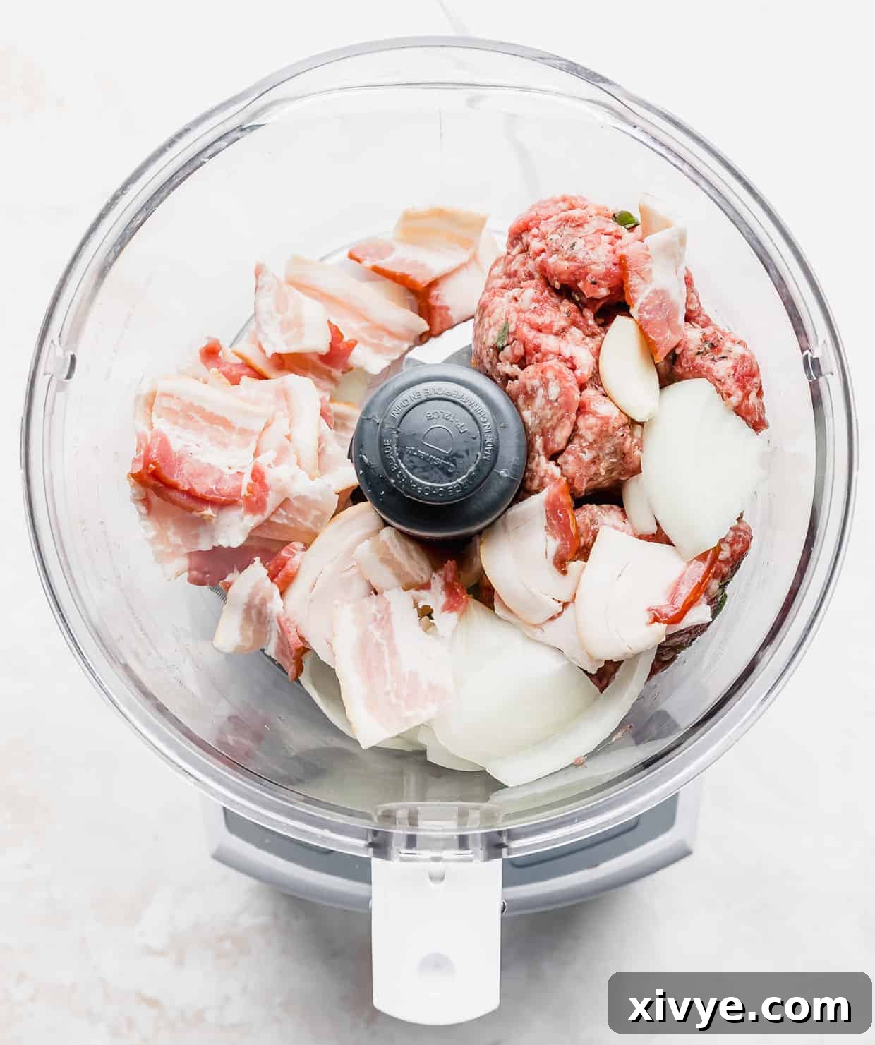 Tender Lamb Gyros 4 A food processor with raw bacon, onion, and ground lamb in it.