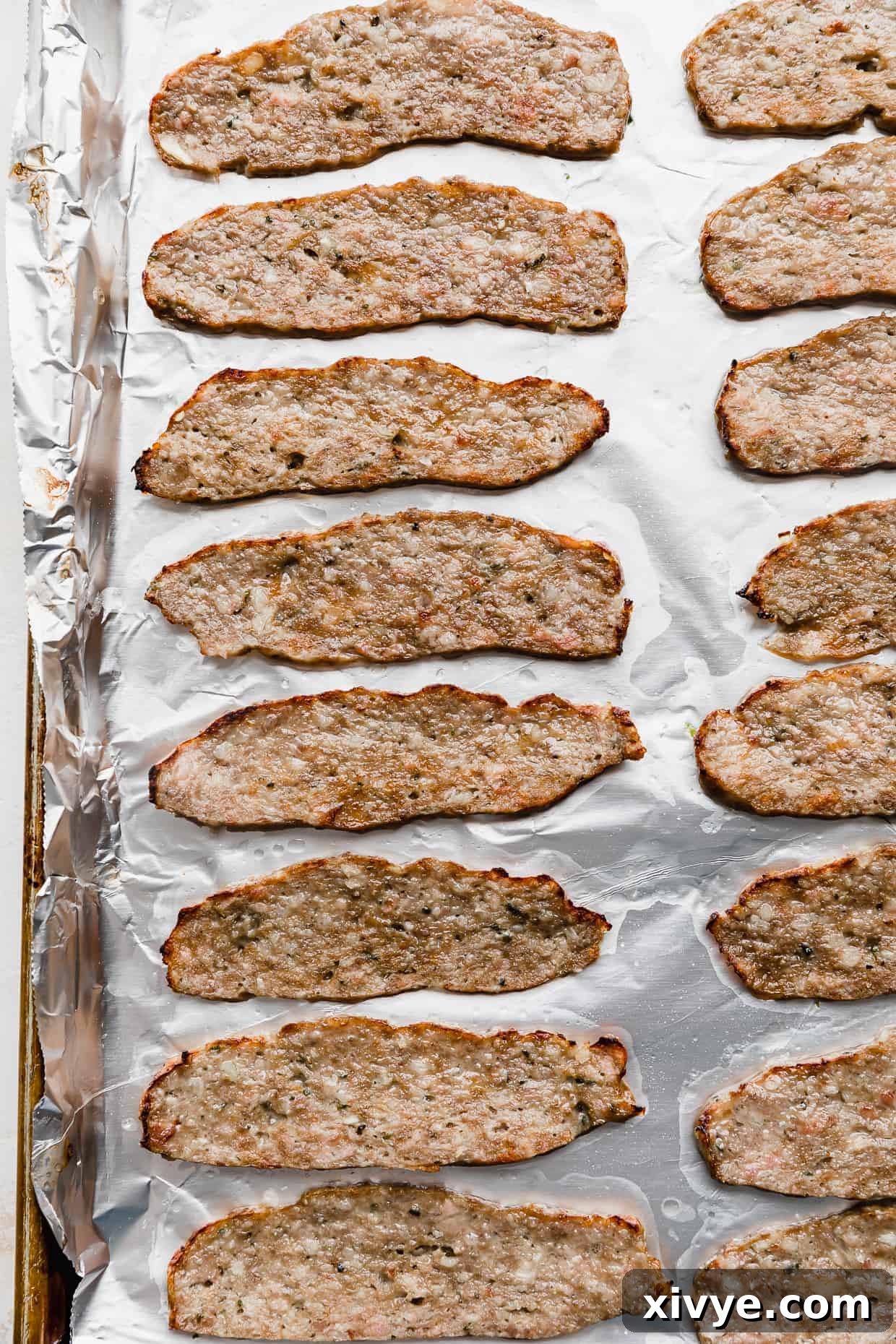 Tender Lamb Gyros 8 Thinly sliced lamb meat on a baking sheet for making lamb gyros.