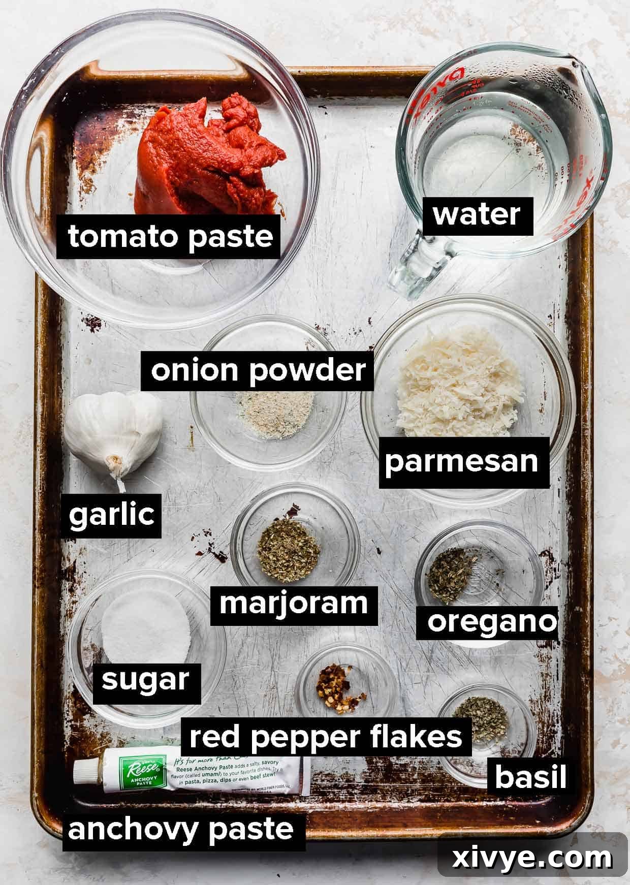 A collection of fresh ingredients laid out, ready to be used for making tomato paste pizza sauce.