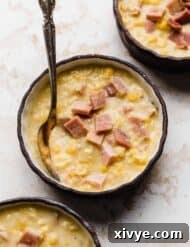 Creamy Ham and Sweet Corn Chowder 13 A close up of Ham and Corn Chowder in a black bowl against a white textured background.