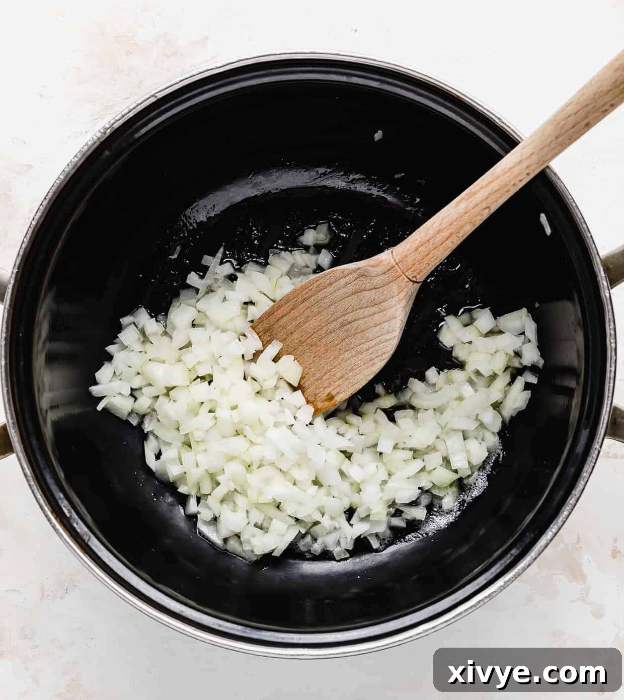 Creamy Ham and Sweet Corn Chowder 4 A black pot with diced yellow onion in it.