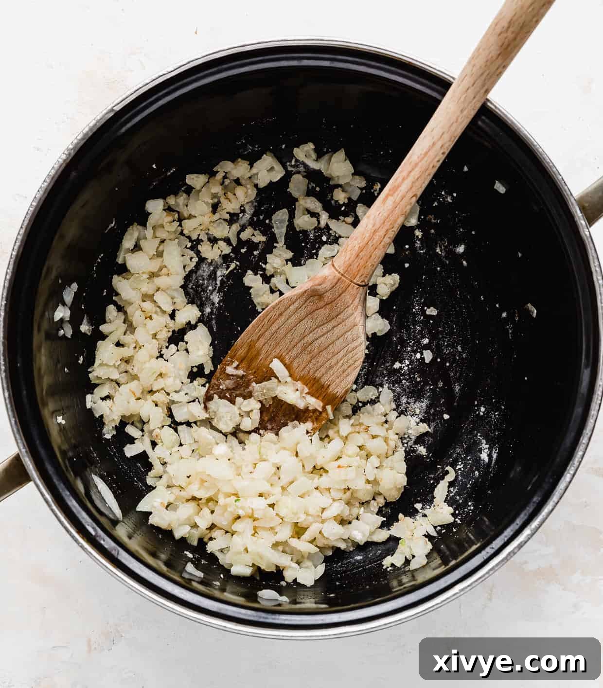 Creamy Ham and Sweet Corn Chowder 5 Diced onion mixed with flour in a black pot.