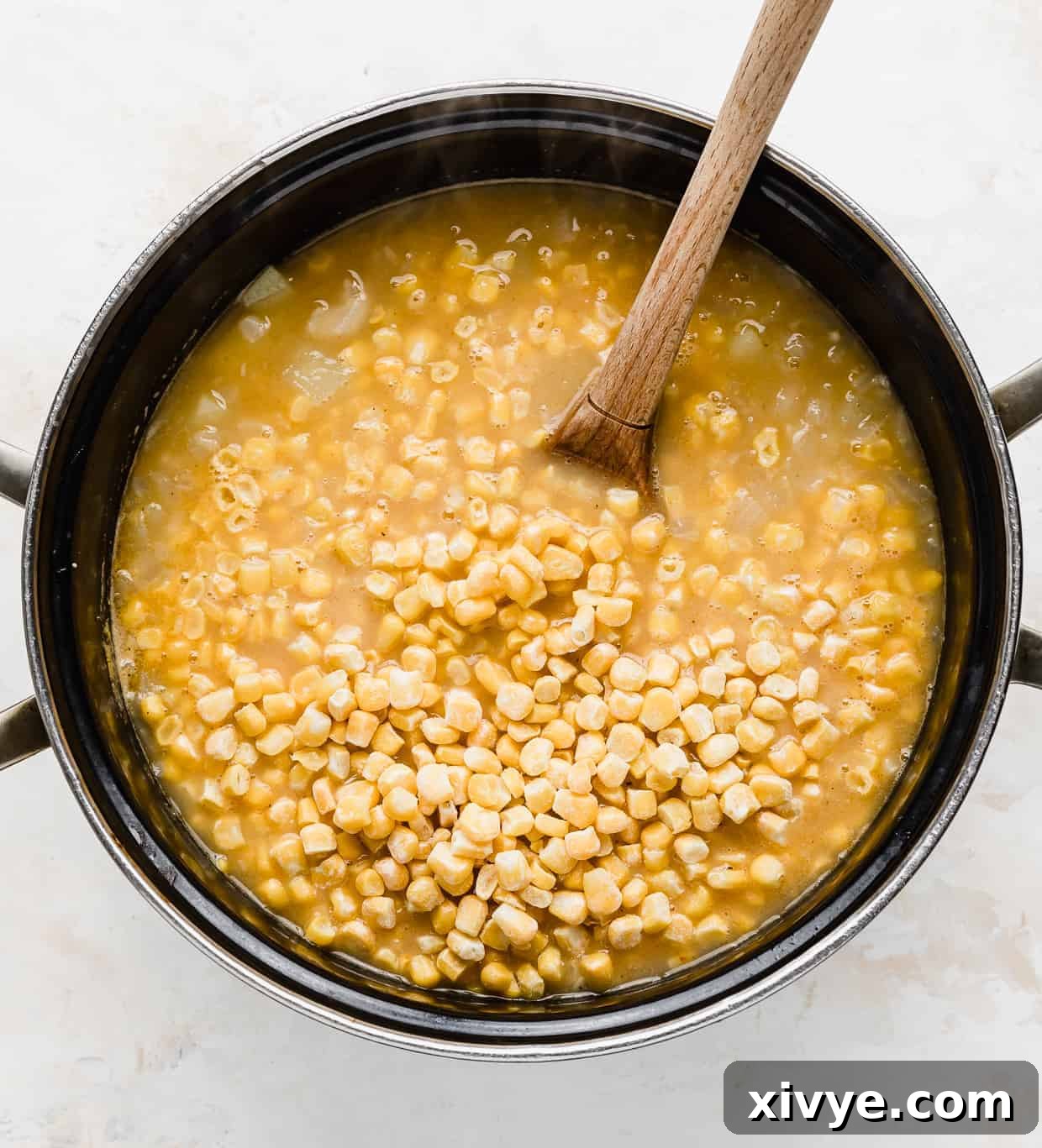 Creamy Ham and Sweet Corn Chowder 7 A pot with frozen corn dumped overtop of chicken broth.