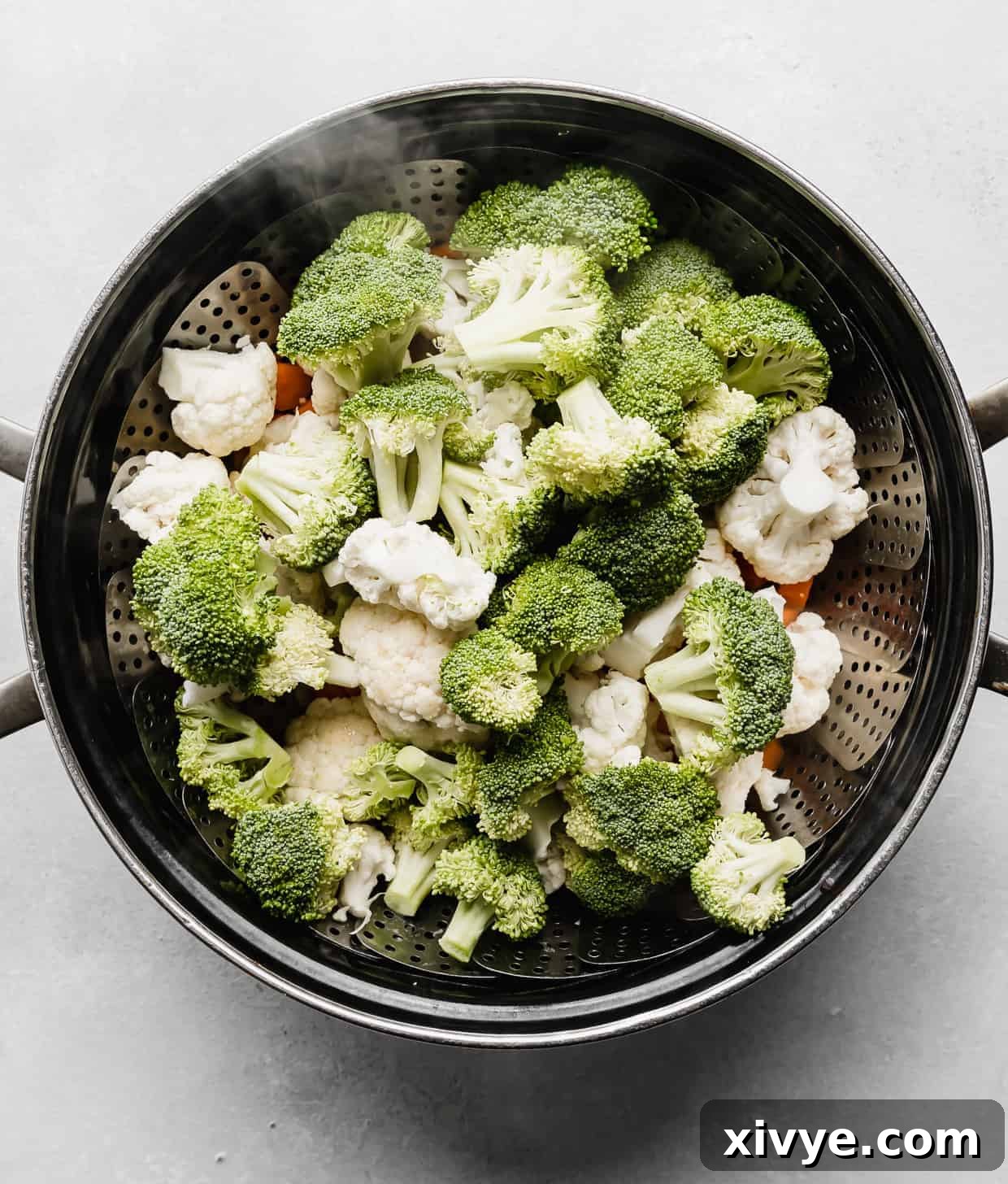 A large pot full of cut broccoli, cauliflower, and carrots.