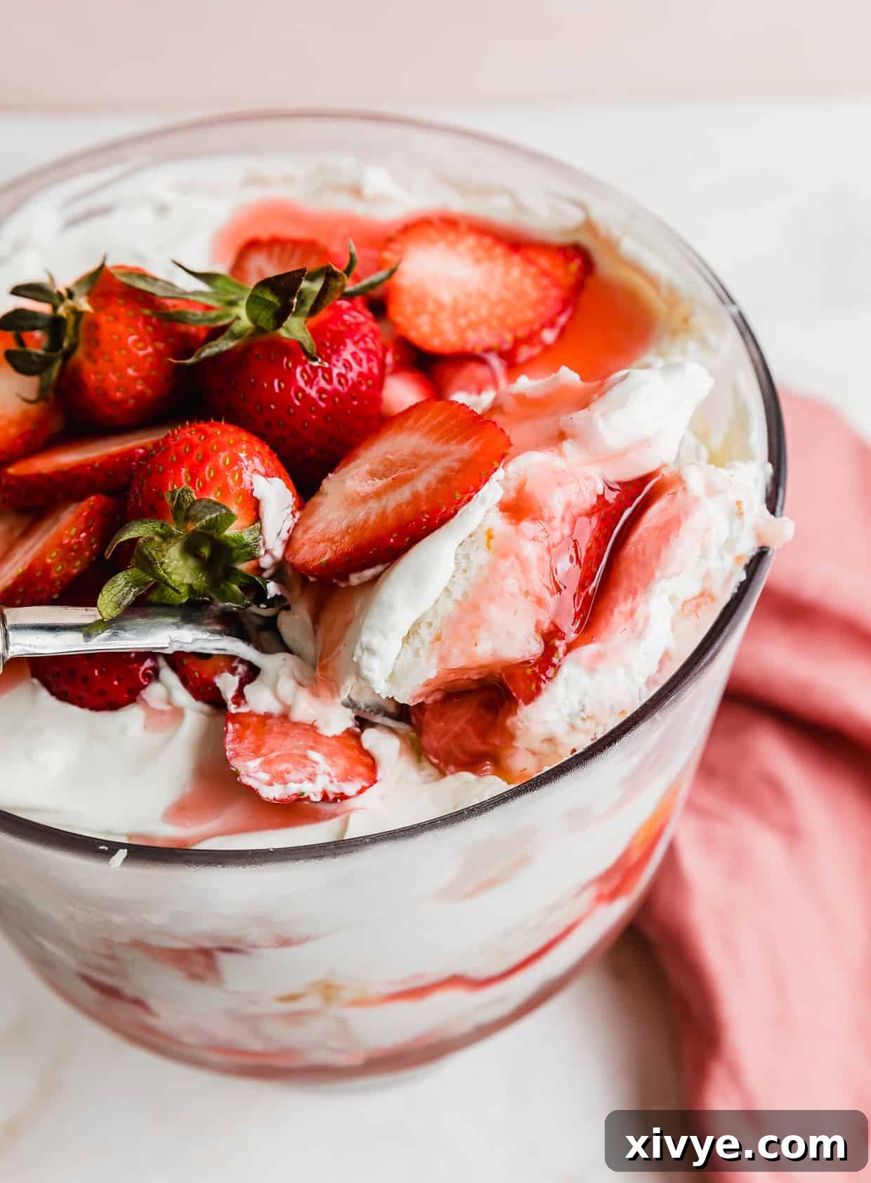 A serving spoon scooping out homemade Strawberry Shortcake Trifle.