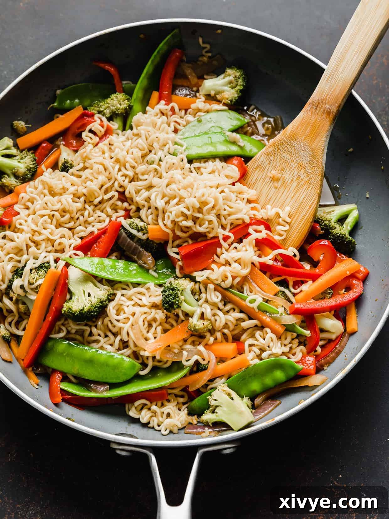 Cooked ramen with vegetables in a gray skillet.