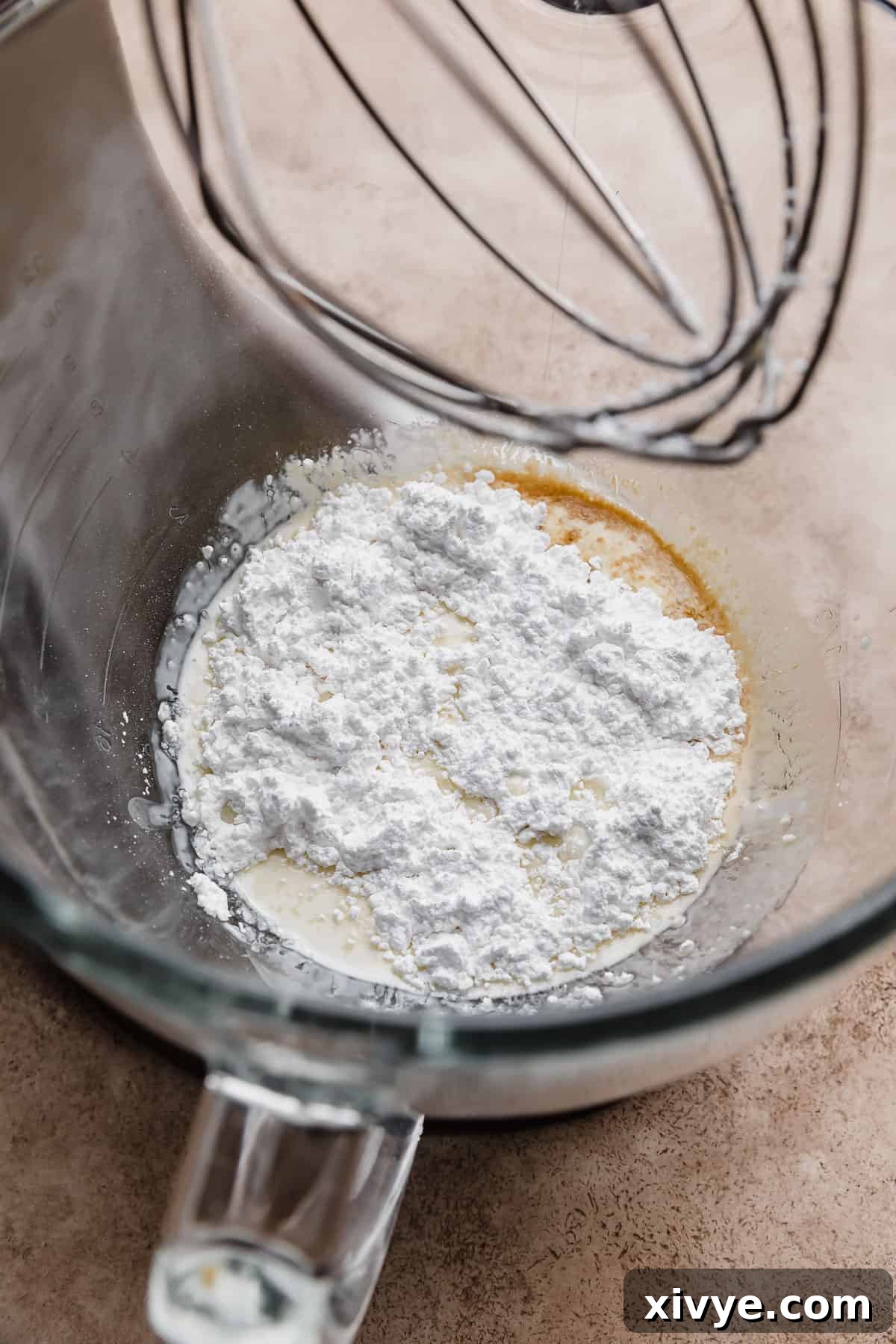 Tangy Greek Yogurt Whip 4 A glass bowl with cold heavy cream and powdered sugar, ready for whipping.