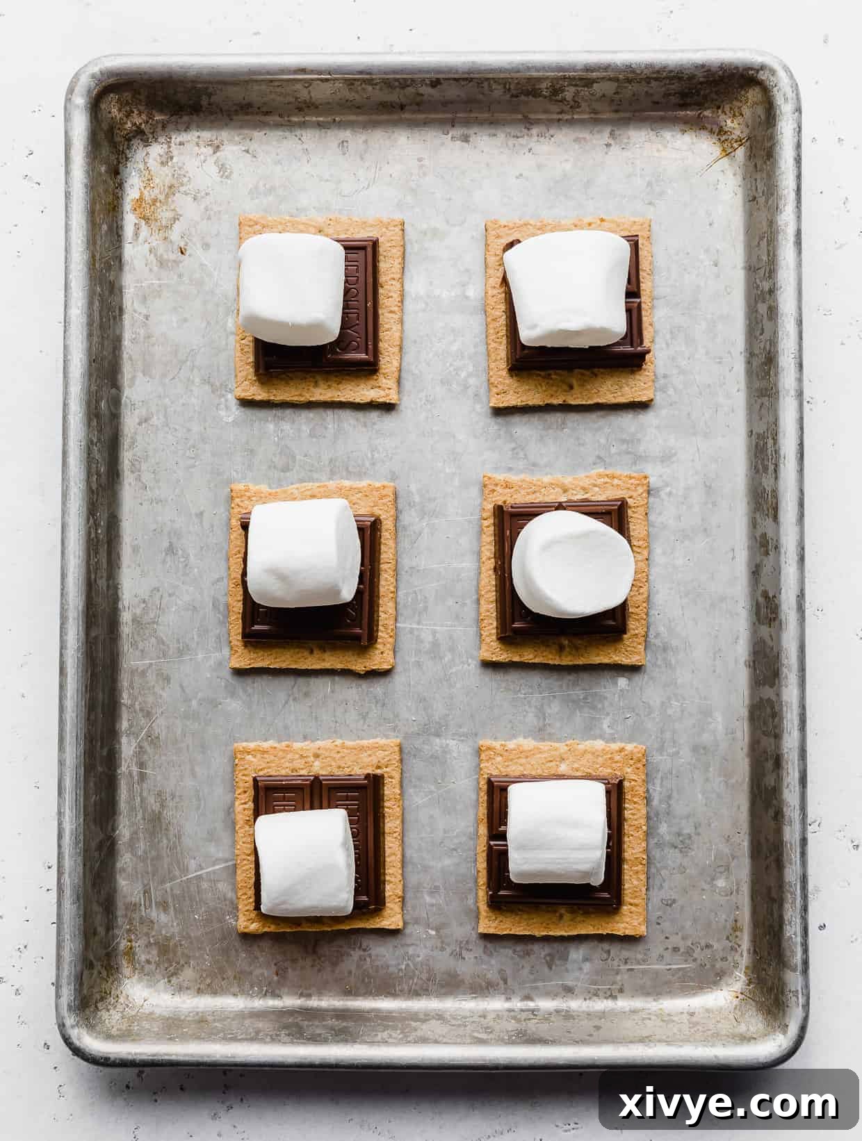 Large marshmallows on top of chocolate and graham cracker squares.