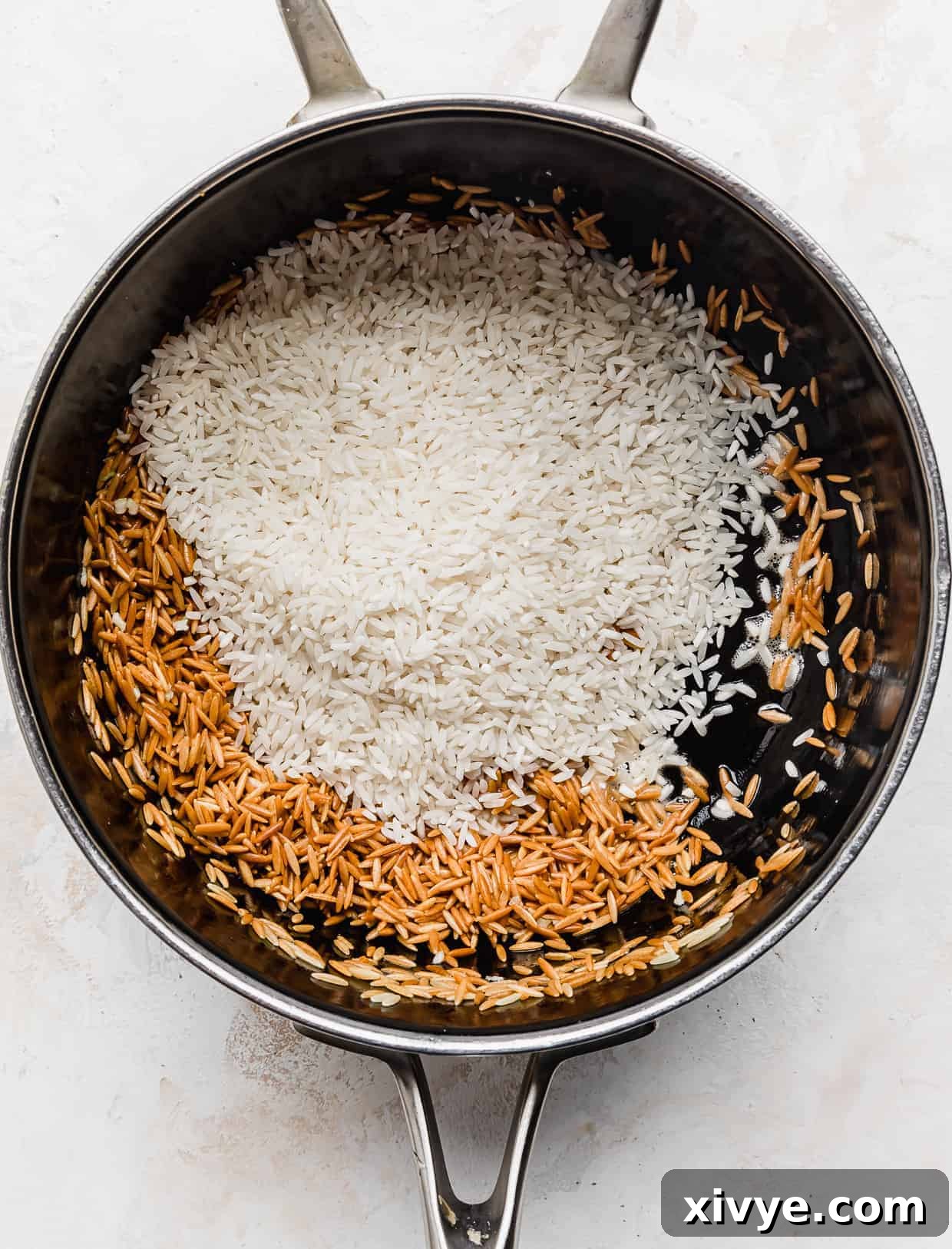 Orzo Pilaf 6 Uncooked white rice is added to the saucepan, resting atop the beautifully toasted golden brown orzo pasta.