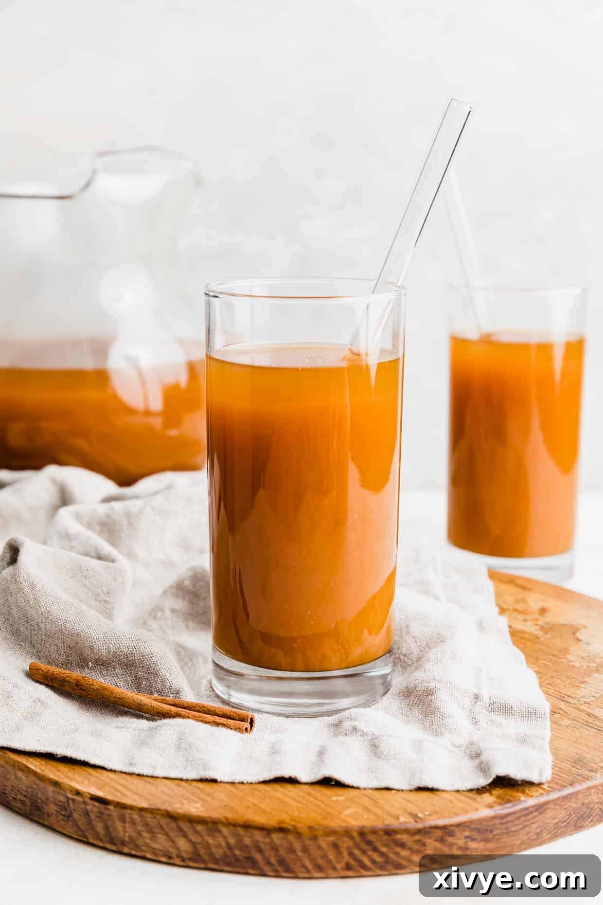 Two glasses or deep orange Harry Potter pumpkin juice against a white background. 