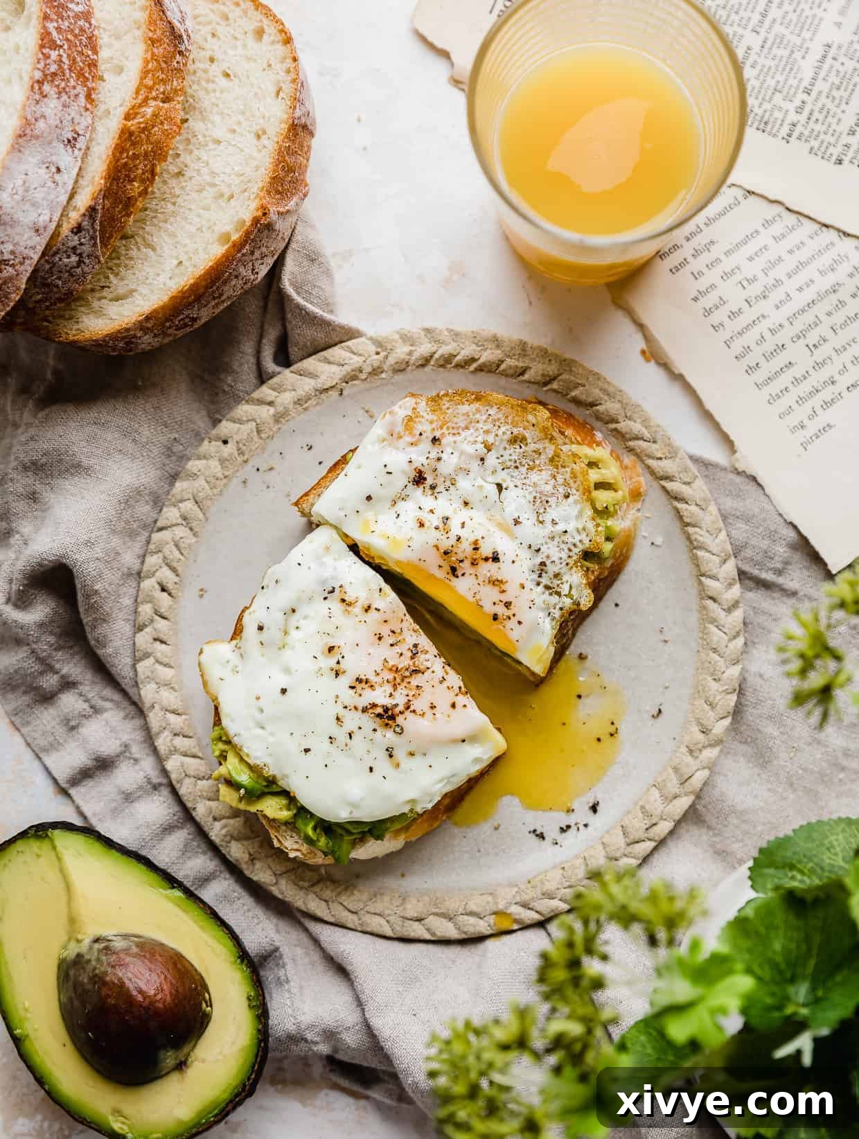 Creamy Avocado Egg Toast 2 Avocado and Egg Toast cut in half on a plate, showcasing a perfectly cooked egg yolk and creamy avocado spread.