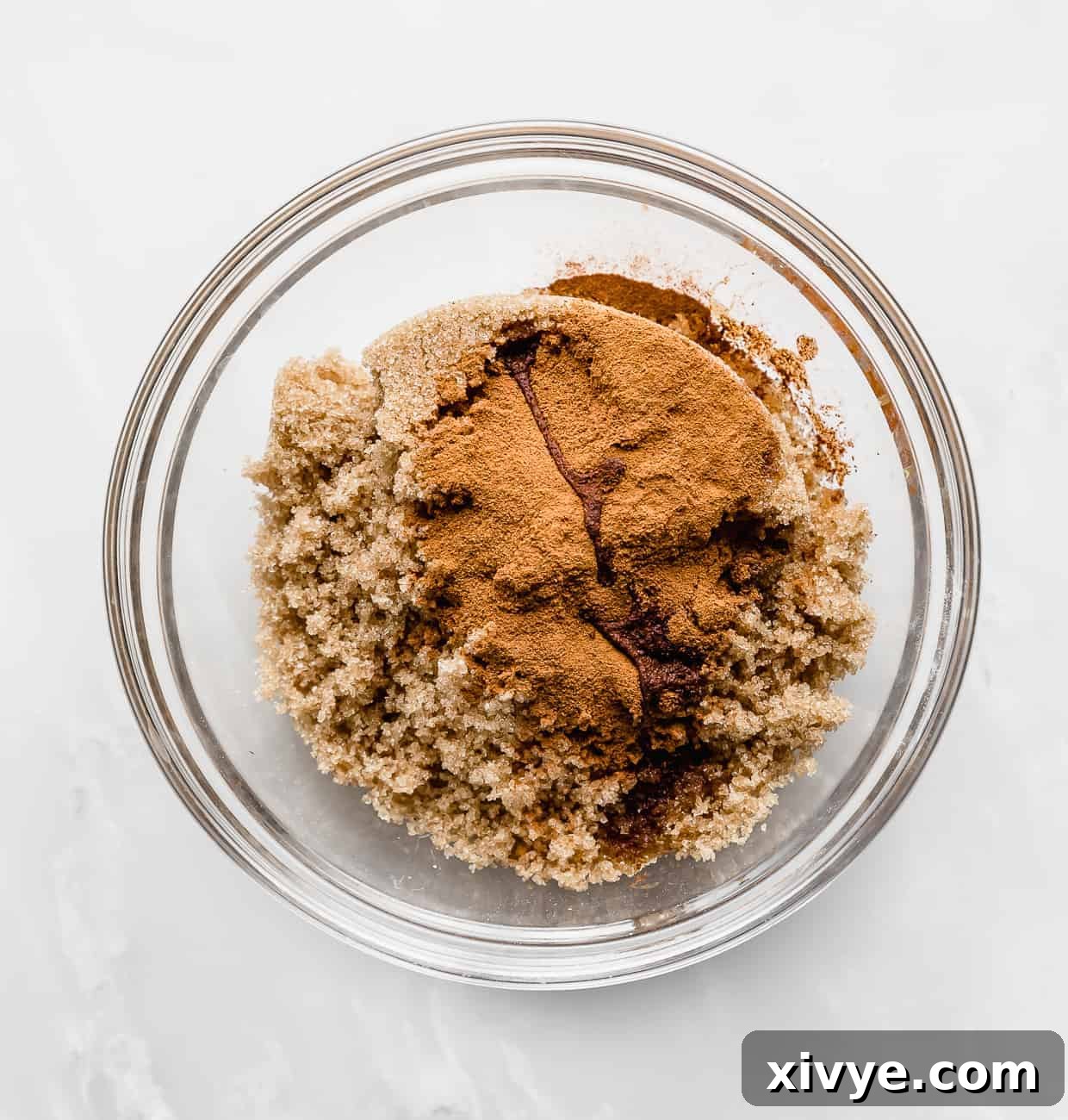 Irresistible Mini Cinnies 10 Brown sugar, cinnamon, vanilla extract, and almond extract in a glass bowl, ready to be mixed for the filling.