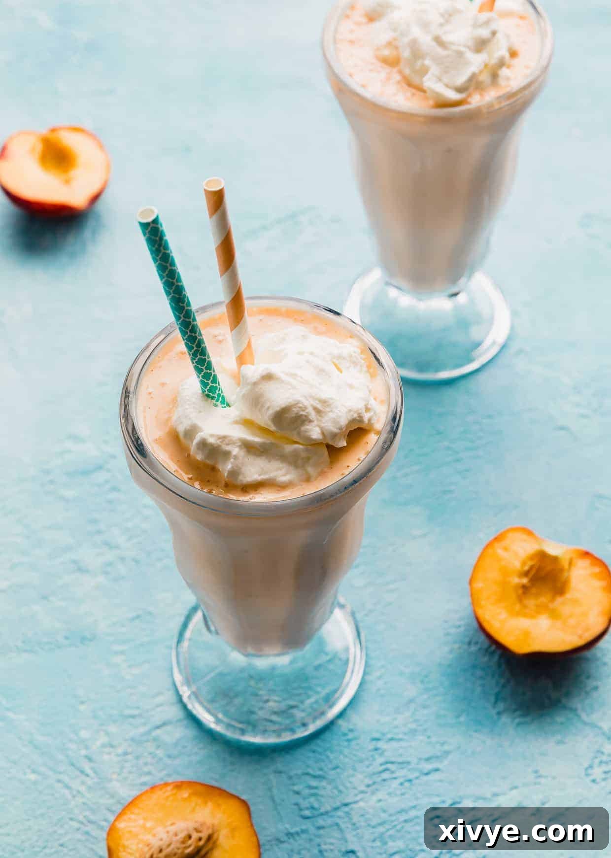Perfect Peach Milkshake Inspired by Chick-fil-A 7 A glass full of Peach Milkshake with a blue straw and peach colored straw in the drink.