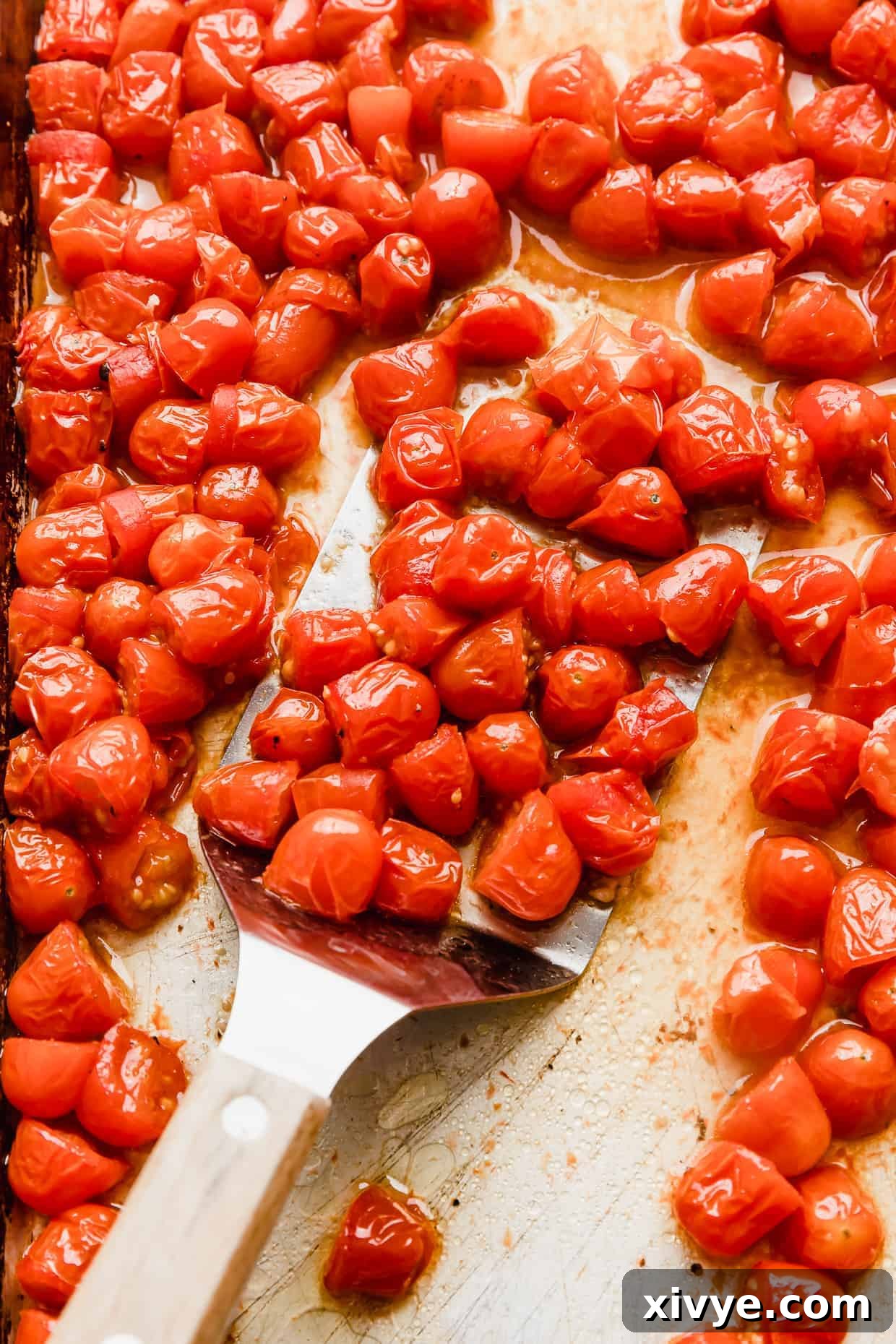 Roasted grape tomatoes on a baking sheet.