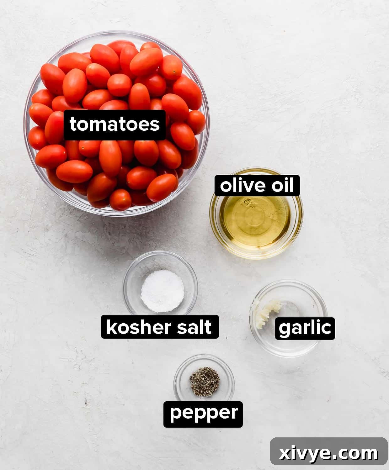 Ingredients used to make roasted tomatoes, on a gray background.