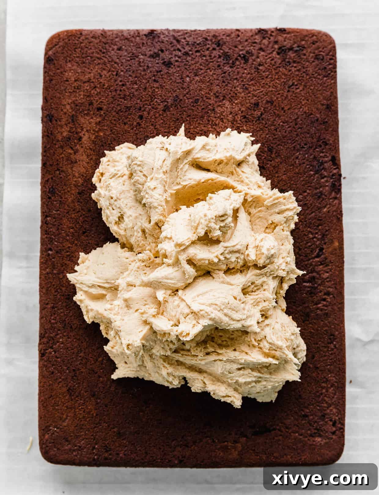 A large dollop of peanut butter frosting on a chocolate cake.