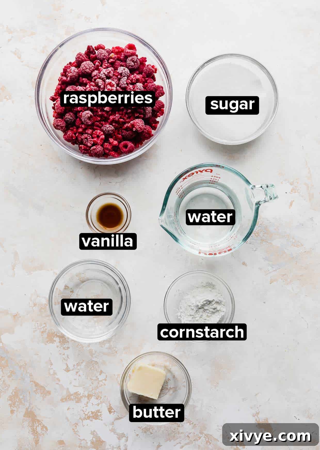 Ingredients used to make raspberry sauce on a cream textured background. 