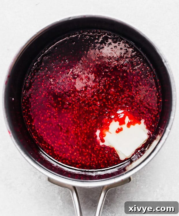 Raspberry sauce and a slice of butter in a small pot.